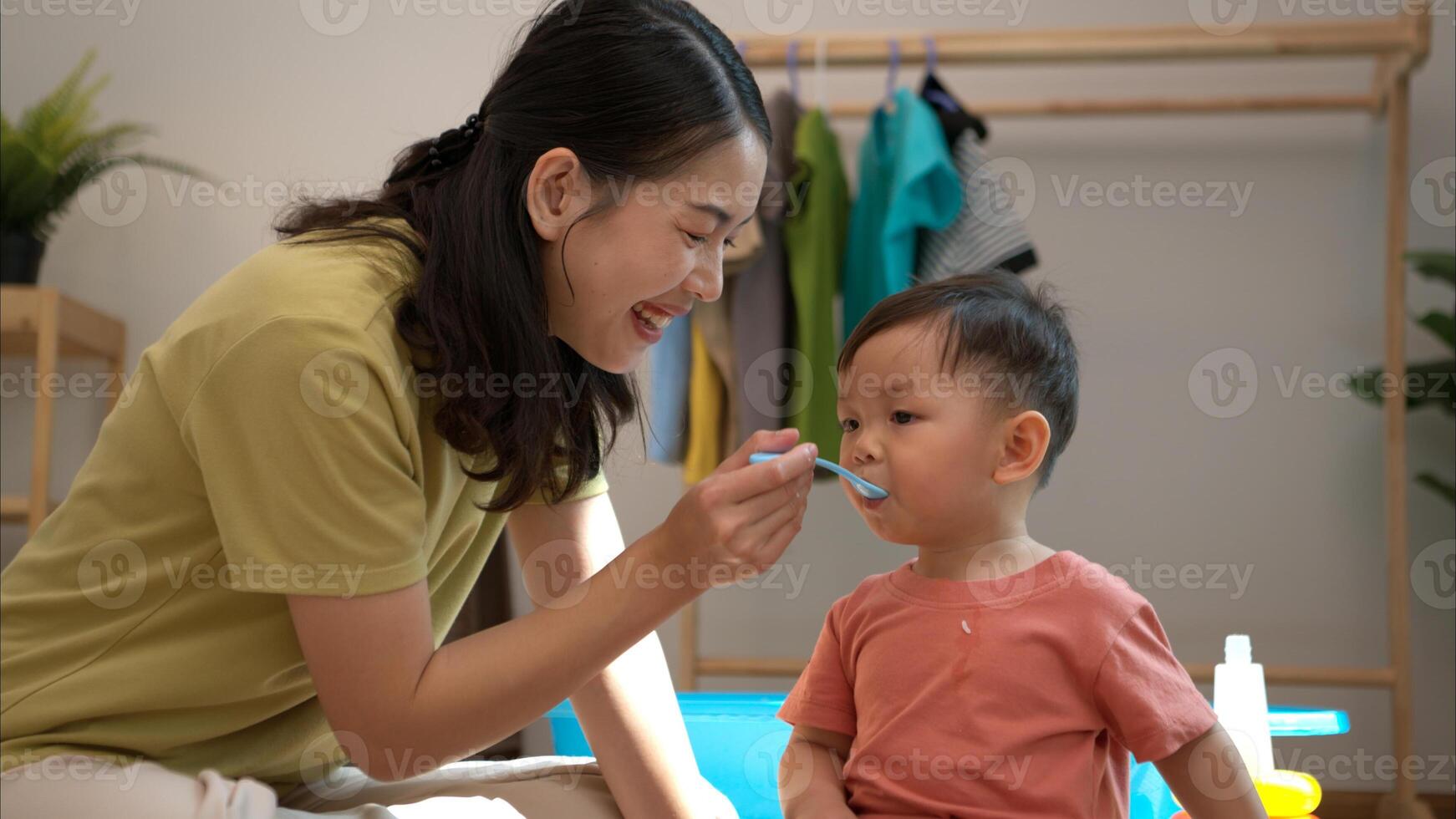 Little boy with breakfast with mom feeding him before bathing him,301 photo