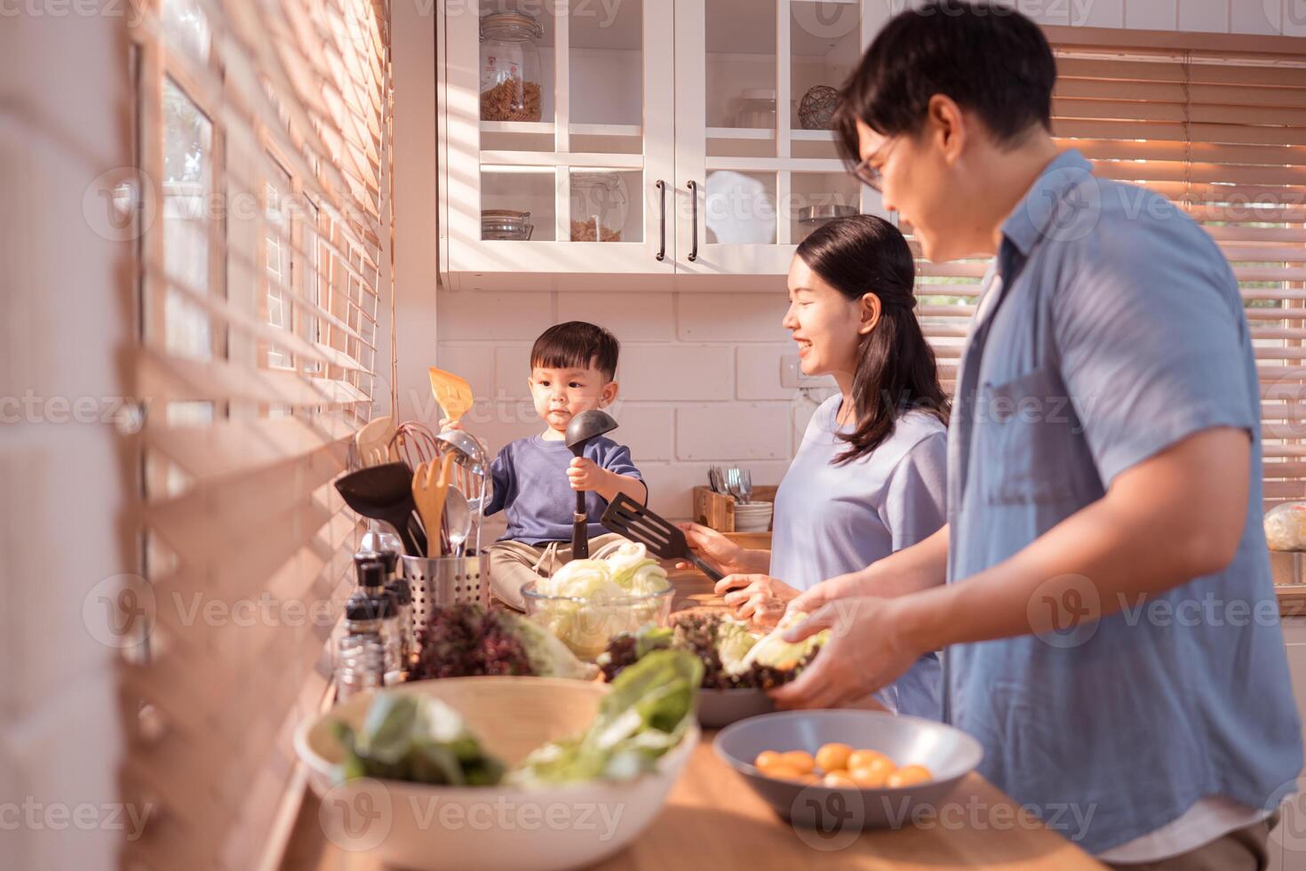 Happy Asian parents enjoying mealtime with their toddler in the kitchen,101 photo