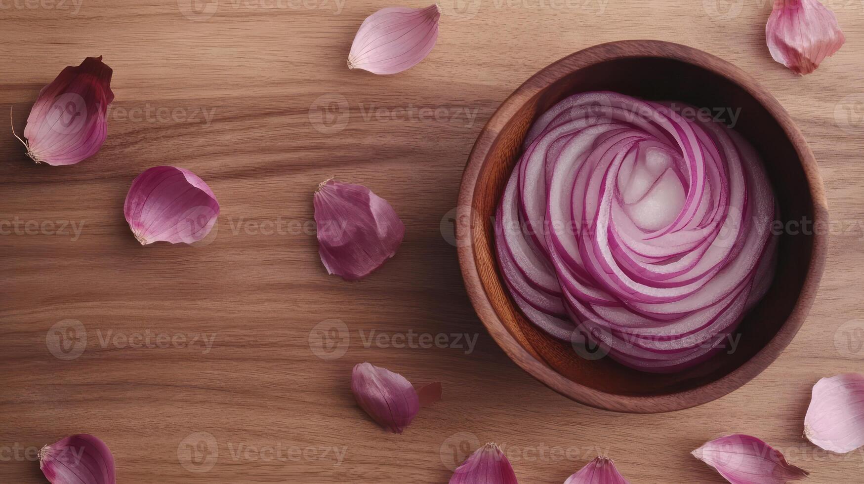 Thinly sliced red onion rings in a wooden bowl, surrounded by onion petals photo