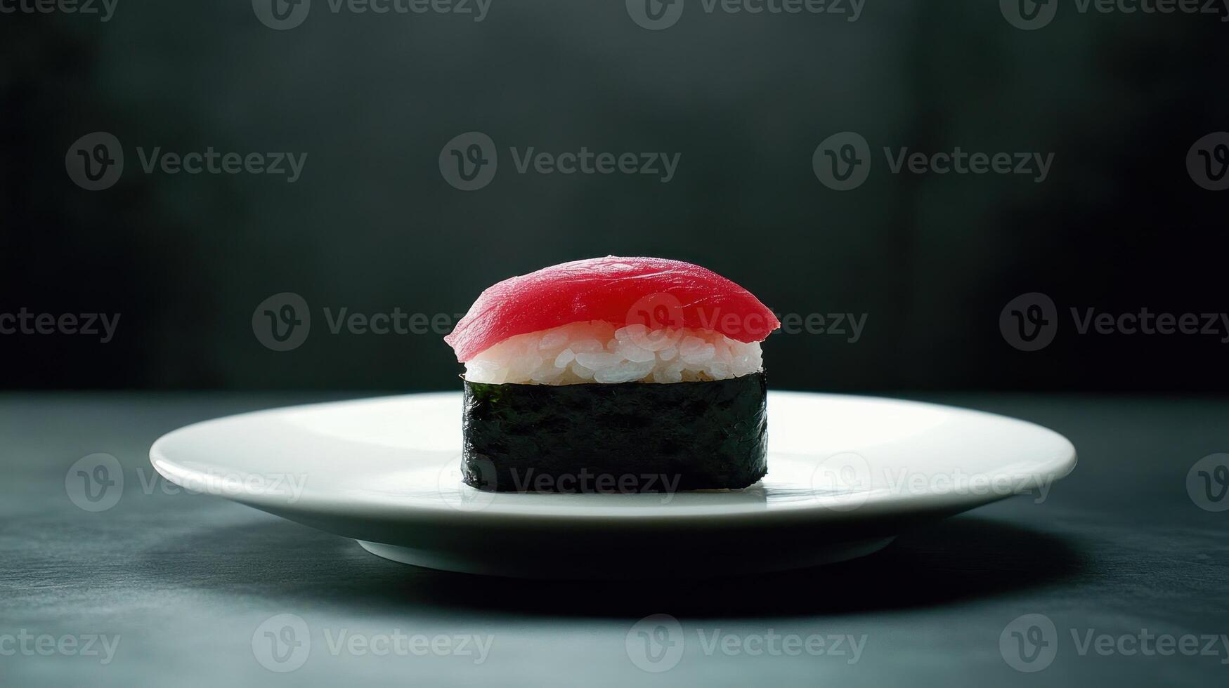 Single piece of sushi on a white plate. A slice of tuna sits atop rice photo