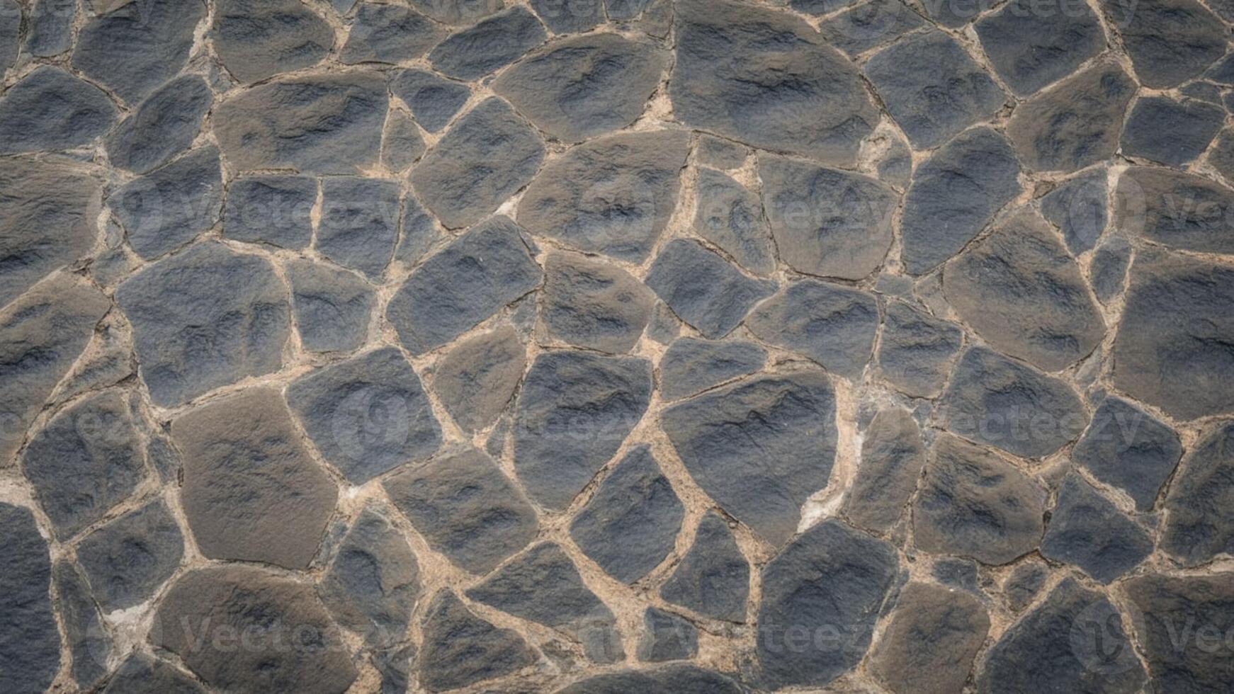 Close up view of a stone wall with irregular shaped stones and light colored grout lines photo