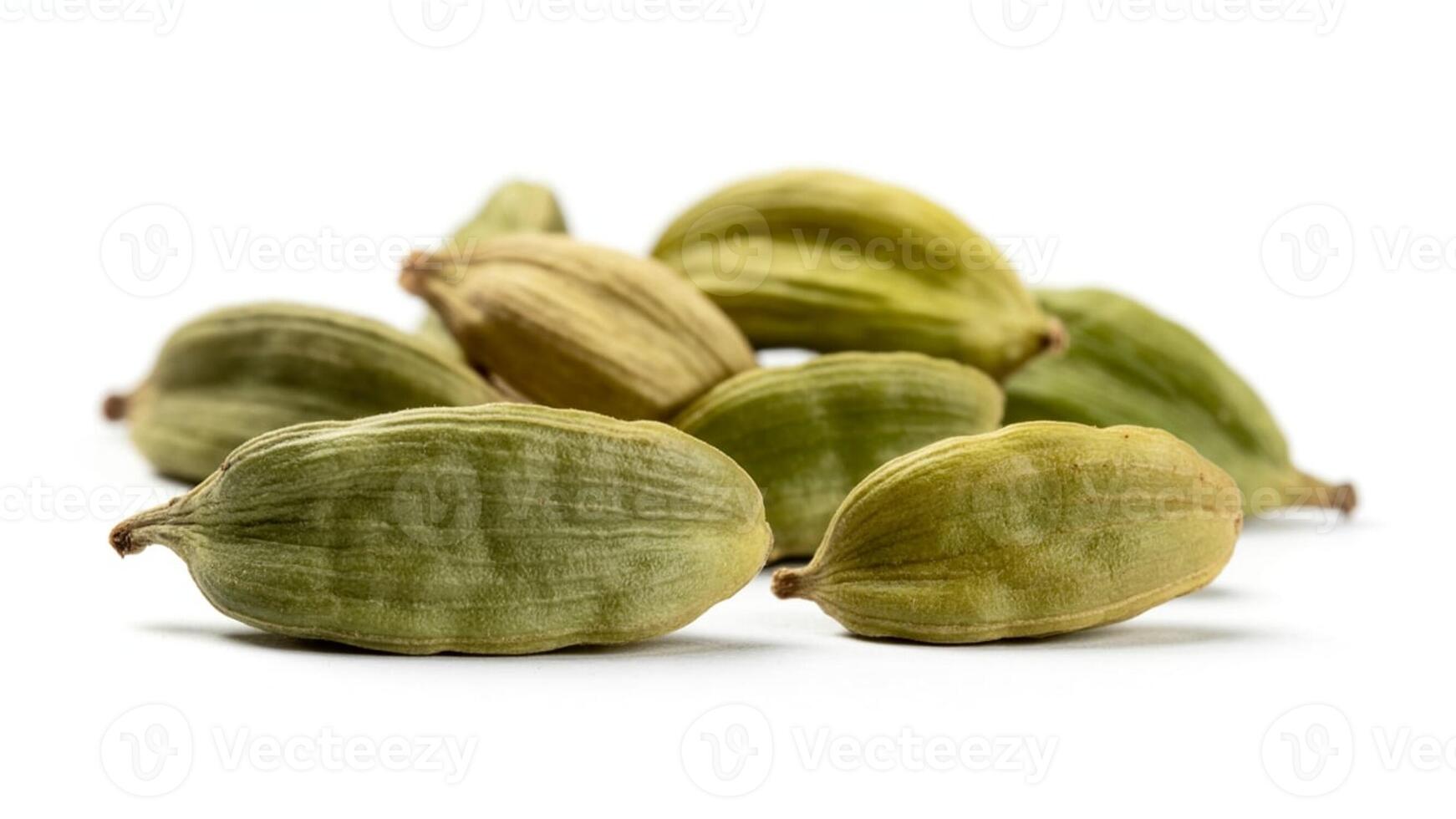 A close up shot of a pile of green cardamom pods on a white surface in a studio setting photo