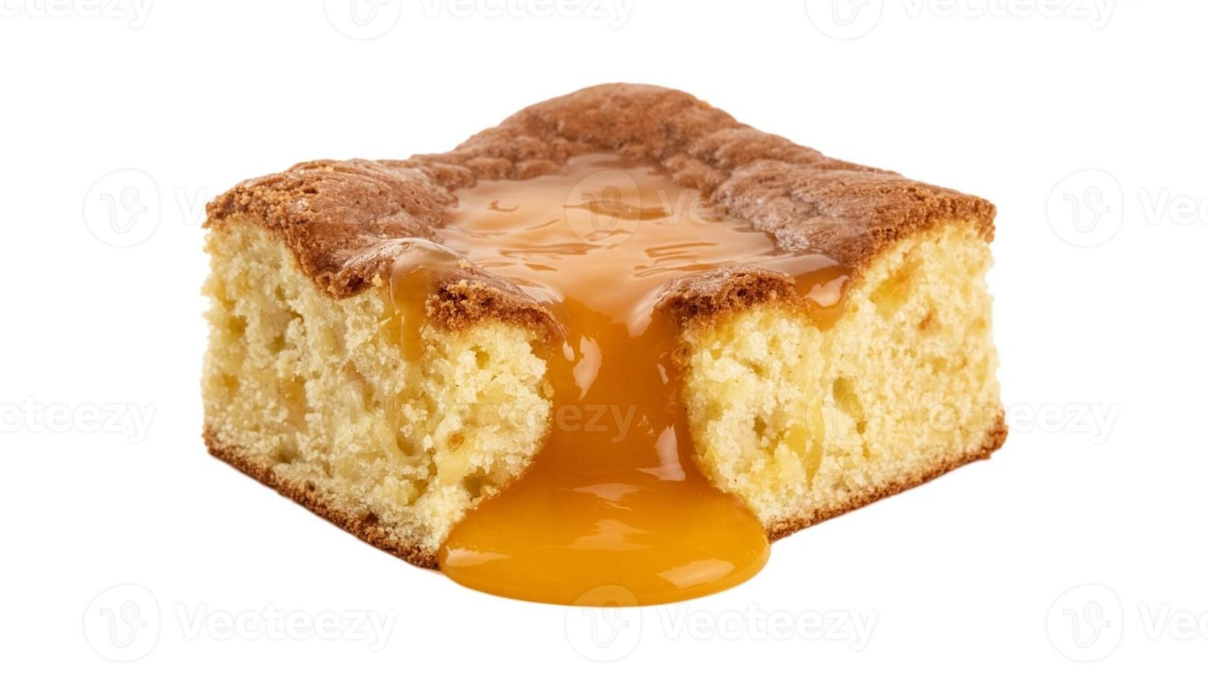 Close up of a square piece of cake with caramel sauce dripping down the side photo