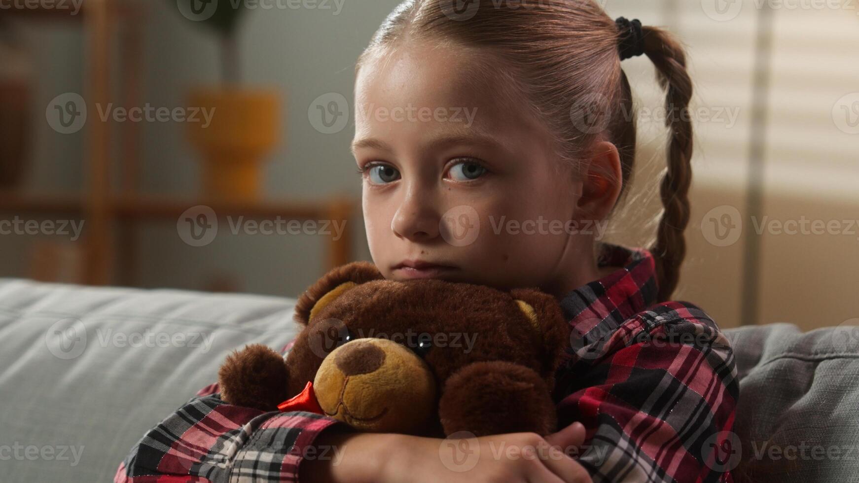 Sad Caucasian child girl hugging toy Teddy Bear sadness upset emotion frustrated lonely kid daughter looking at camera grief orphan parents divorce suffering at home portrait negative stress custody photo