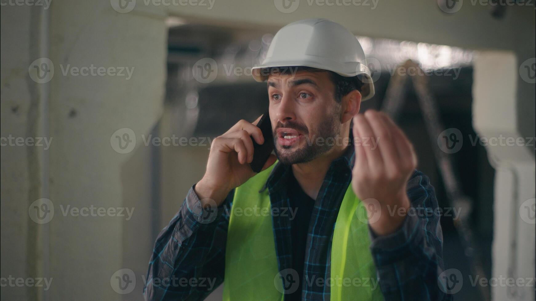 Annoyed Caucasian man contractor holding mobile phone speaking remote call conflict in construction builder foreman arguing furious guy technician building industry working problem upset male argument photo
