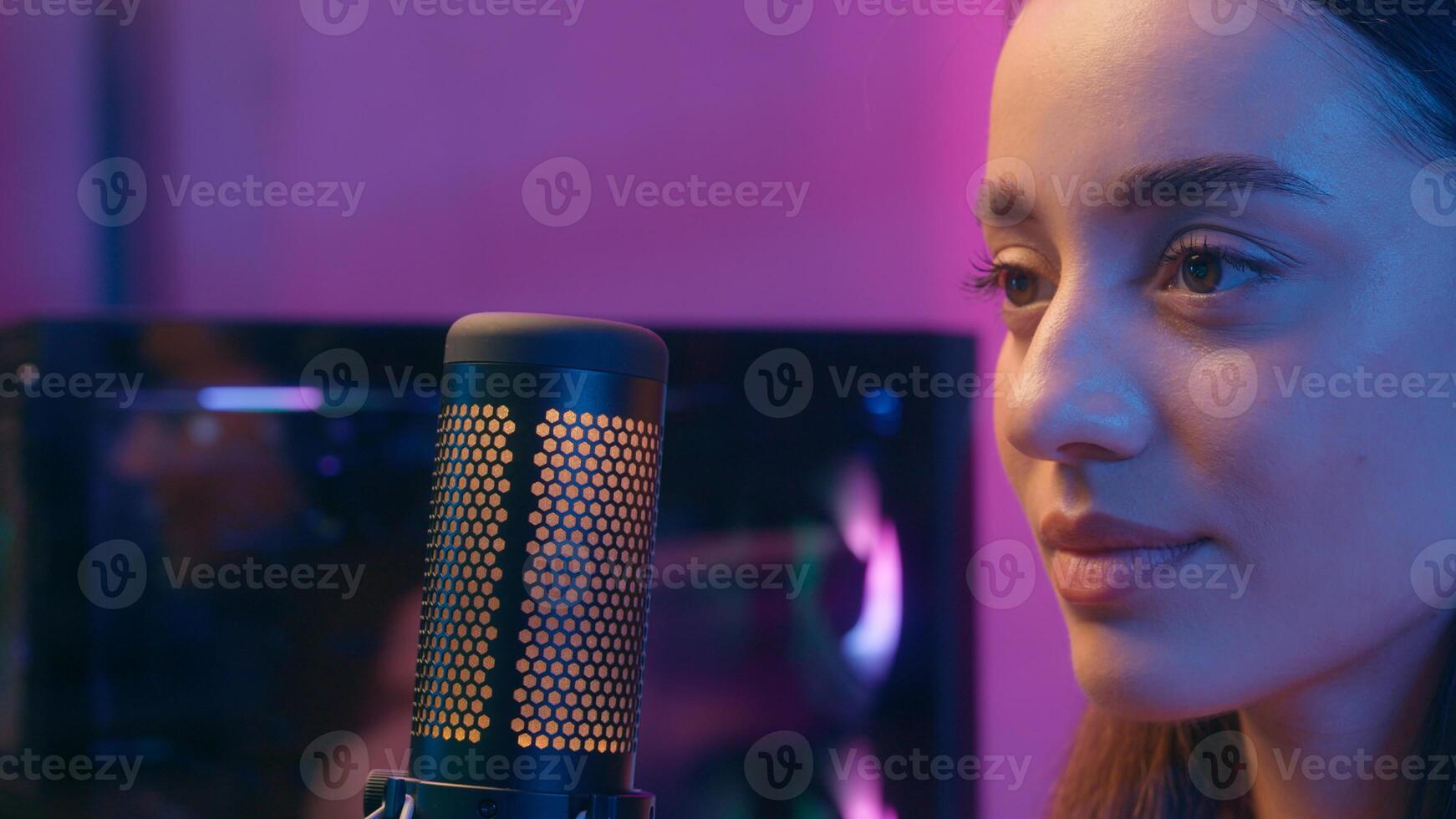 Caucasian girl female woman happy streamer focused influencer online blogger stream wearing headphones microphone computer internet game playing streaming at home evening close up looking at screen photo