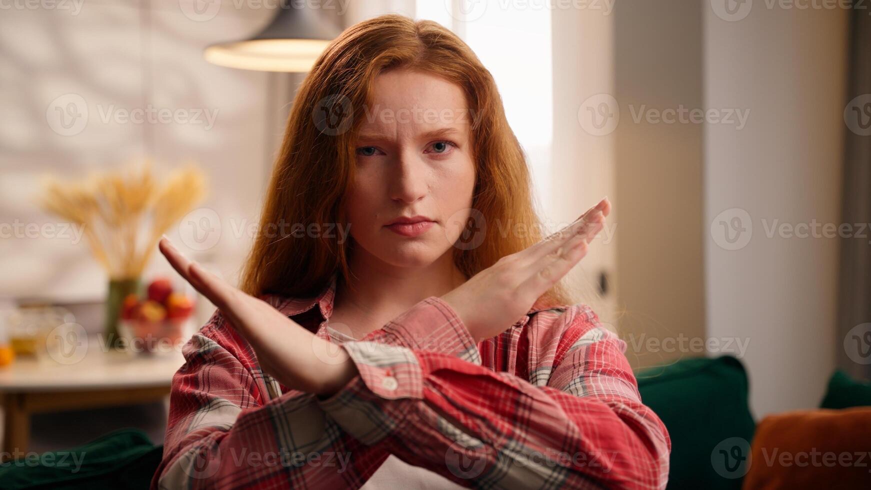 Woman crossed arms stop no gesture not forbidden gesture shaking head no at home girl negative answer looking at camera indoors Caucasian female crossing hands deny in living room end symbol finish photo