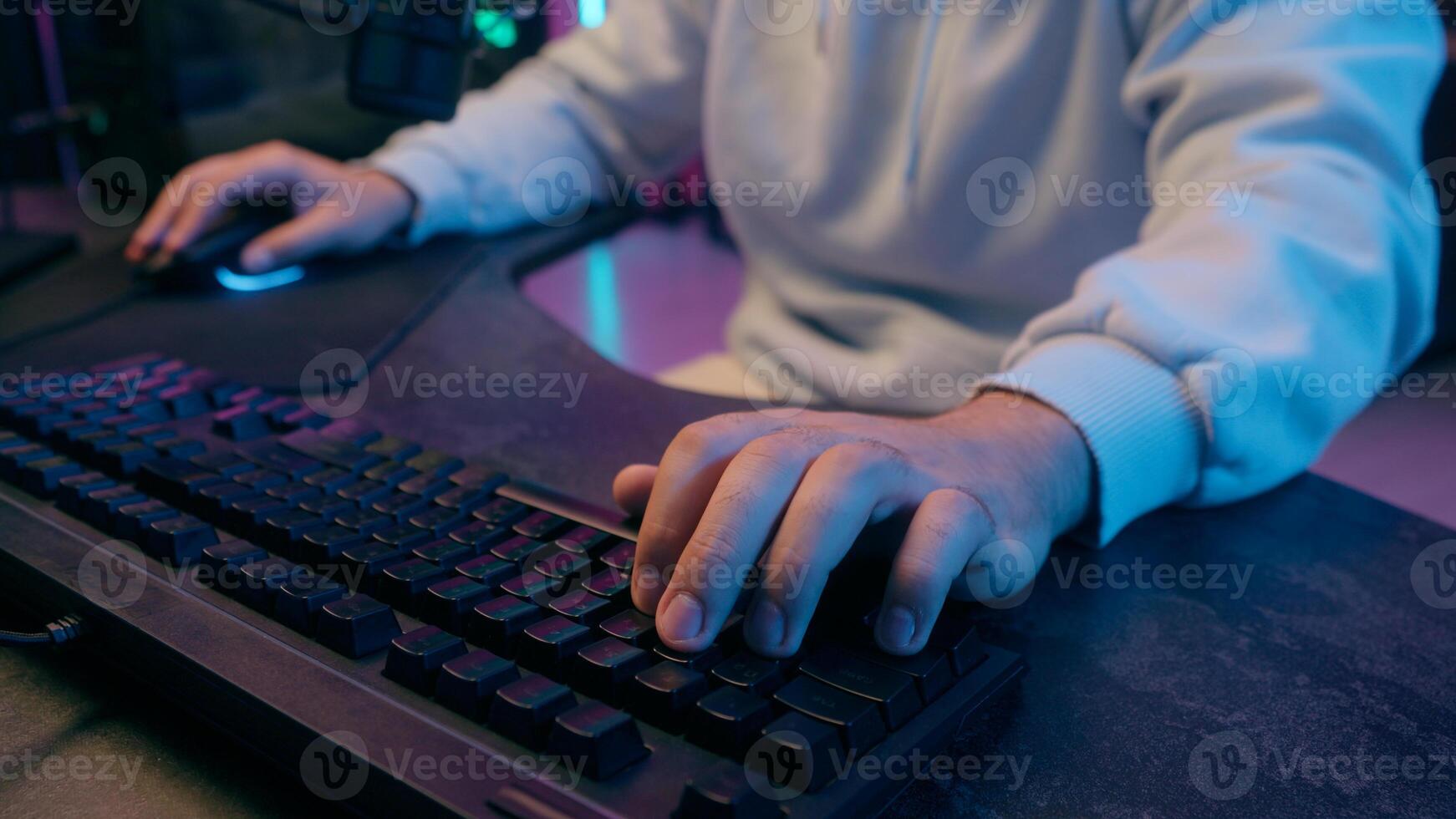 Close up hands arms of Caucasian man male guy gamer streamer typing laptop keyboard gaming addiction play online game addict playing internet computer at night neon light indoors sport streaming photo