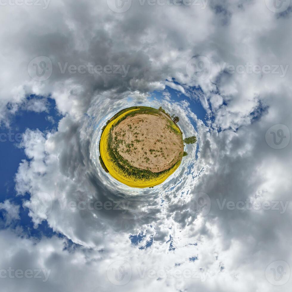 A small planet with clouds and a field of yellow flowers photo