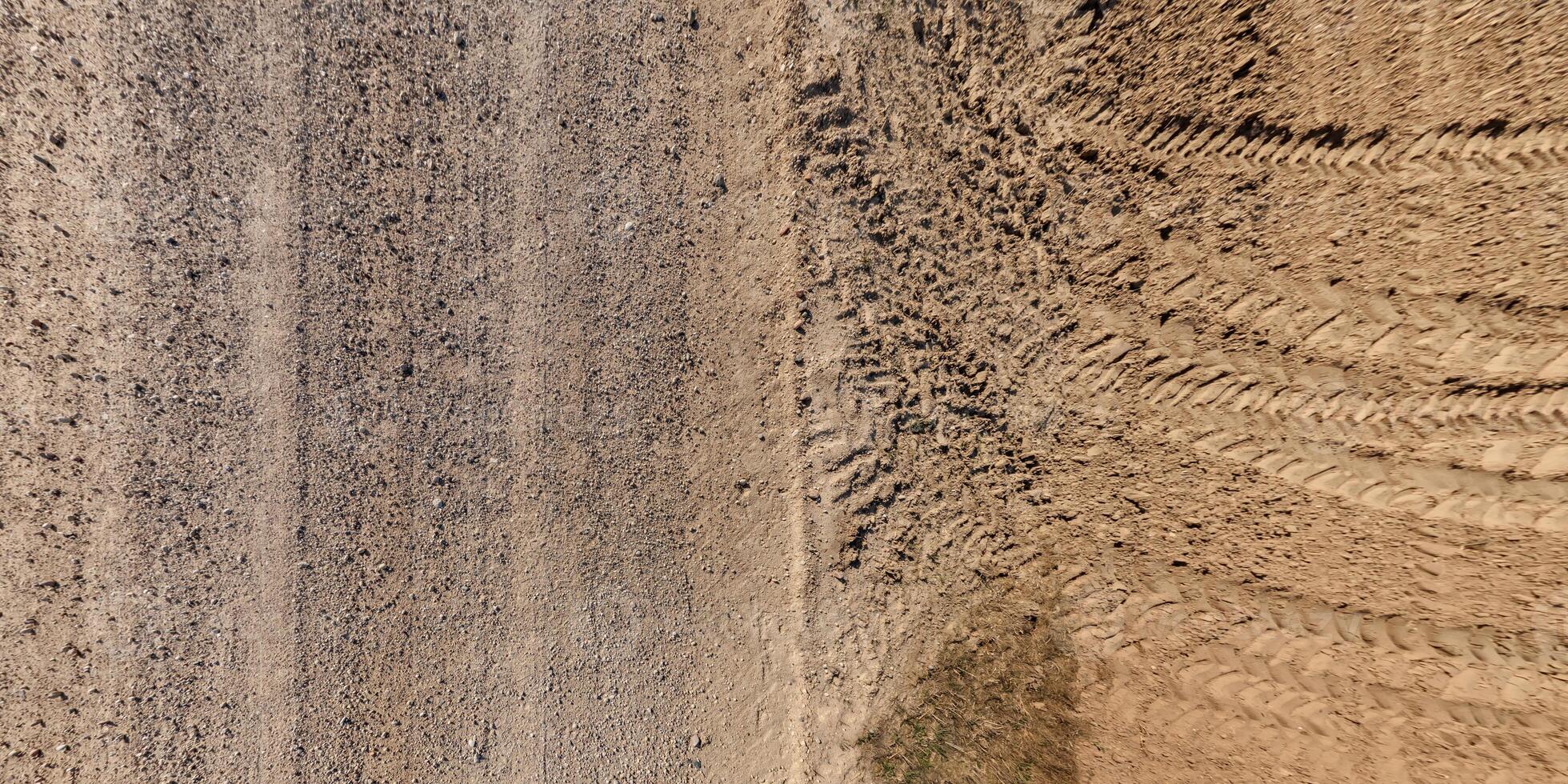 A dirt road with tire tracks and a dirt road photo