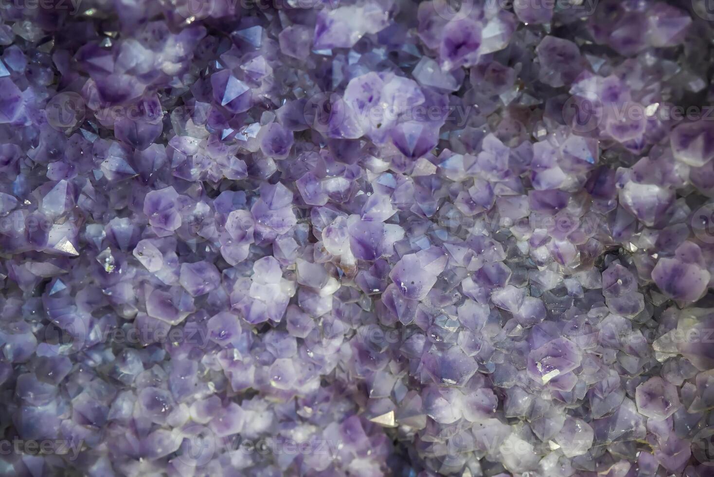 Close-up of natural amethyst crystals with shimmering purple hues, creating a textured abstract background perfect for use as copy space in design. photo