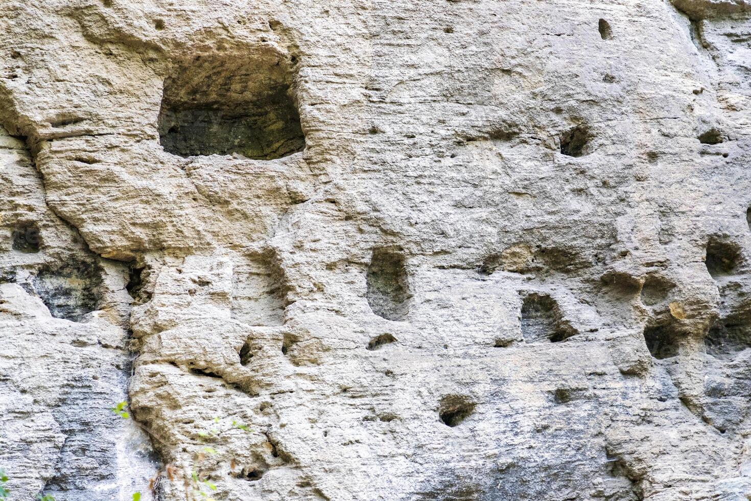 Cells in the face of the rock, used by monks of the cave monastery photo