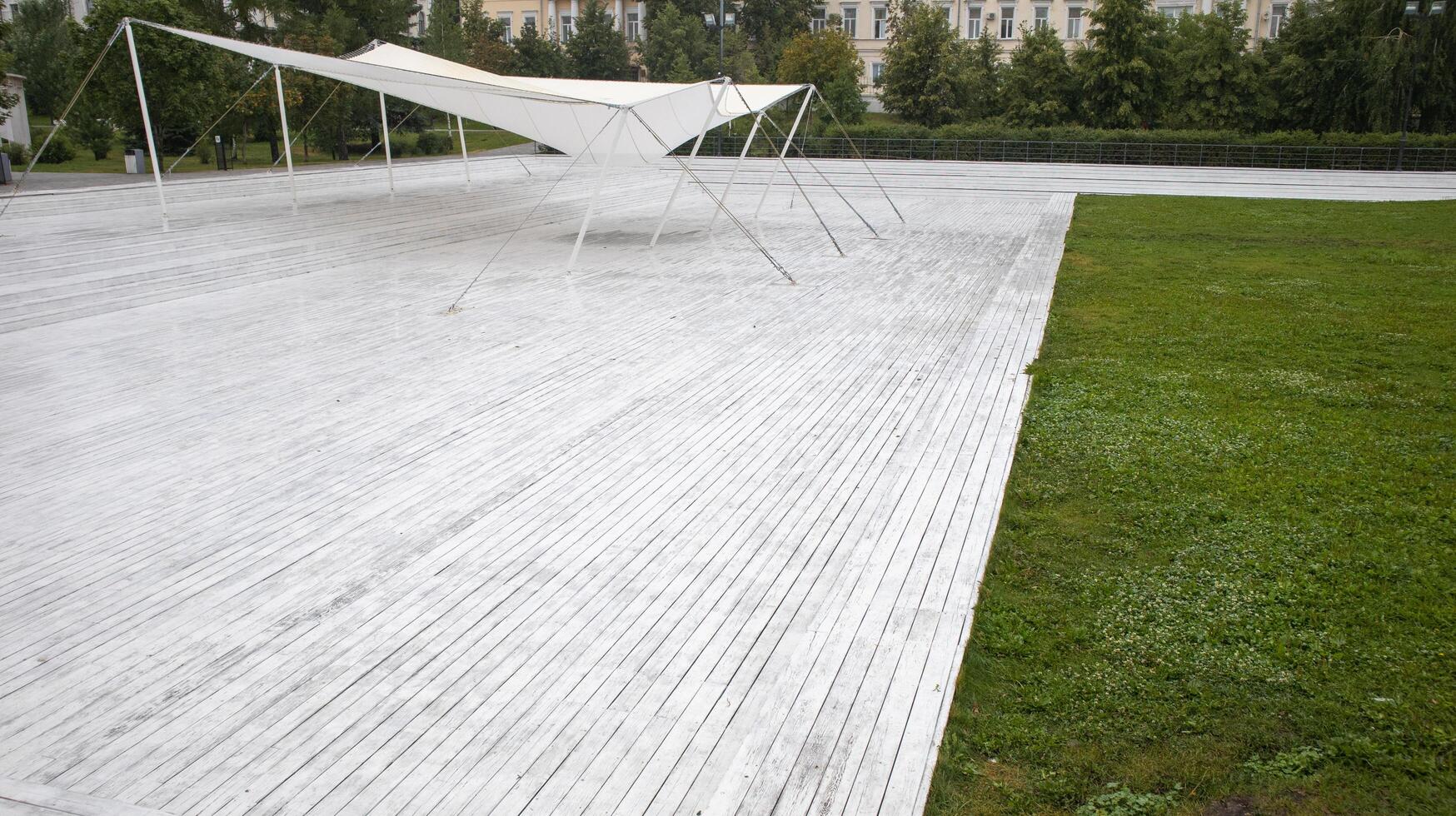 White wood new decking and tarpaulin awning, empty lot in a recreation park. photo