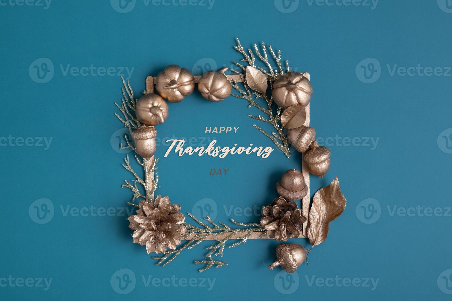 Happy Thanksgiving text with flat lay golden pumpkins and acorns on a turquoise background photo