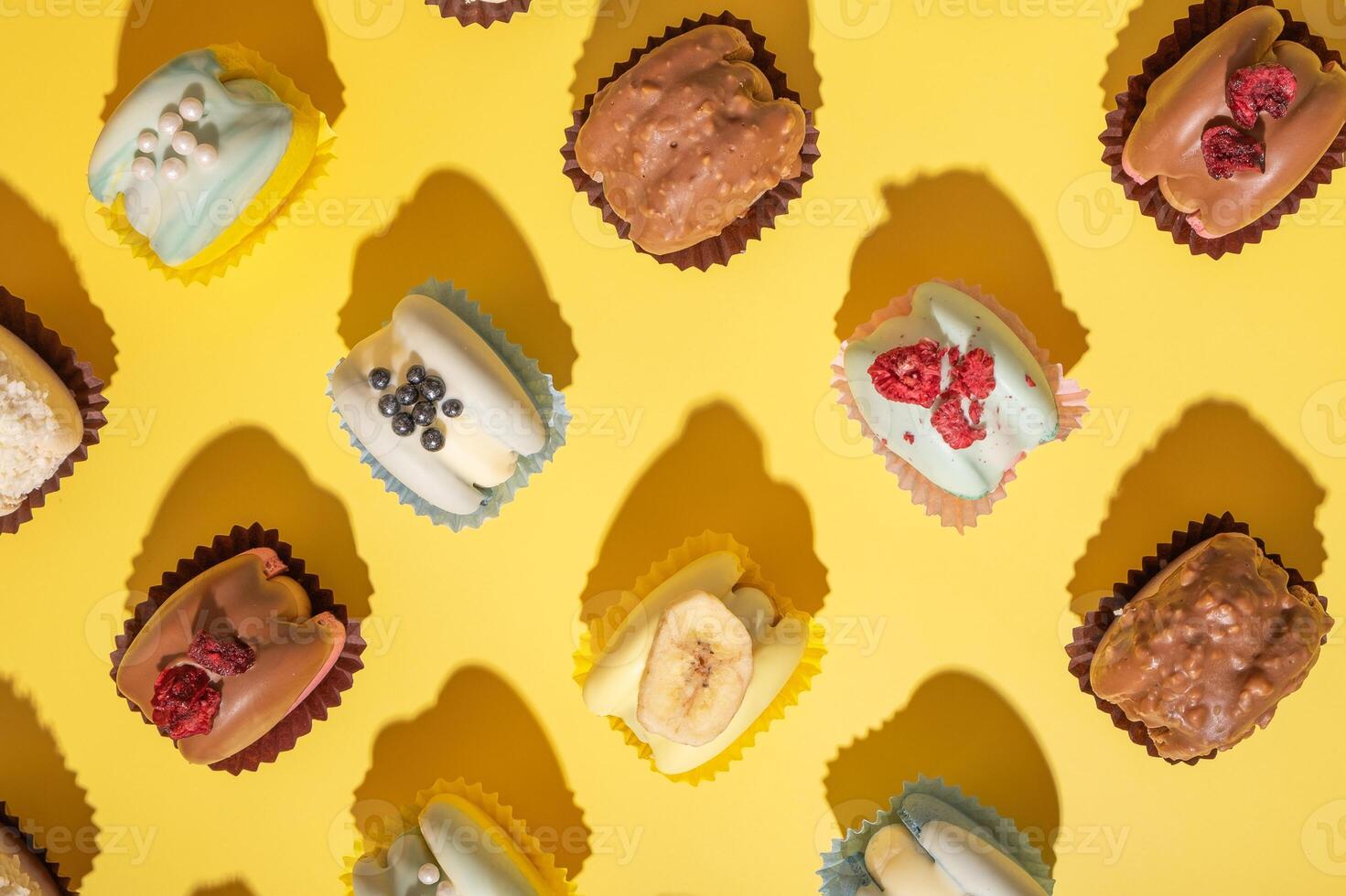 tempting variety of macaroons in pastel shades are arranged on yellow surface photo