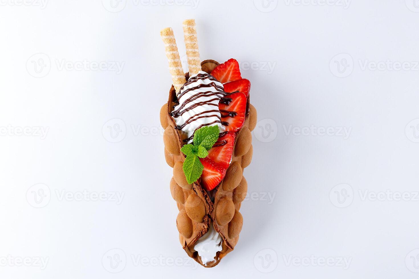 Chocolate Egg Waffle Cone Filled with Cream, Fresh Strawberries and Mint photo