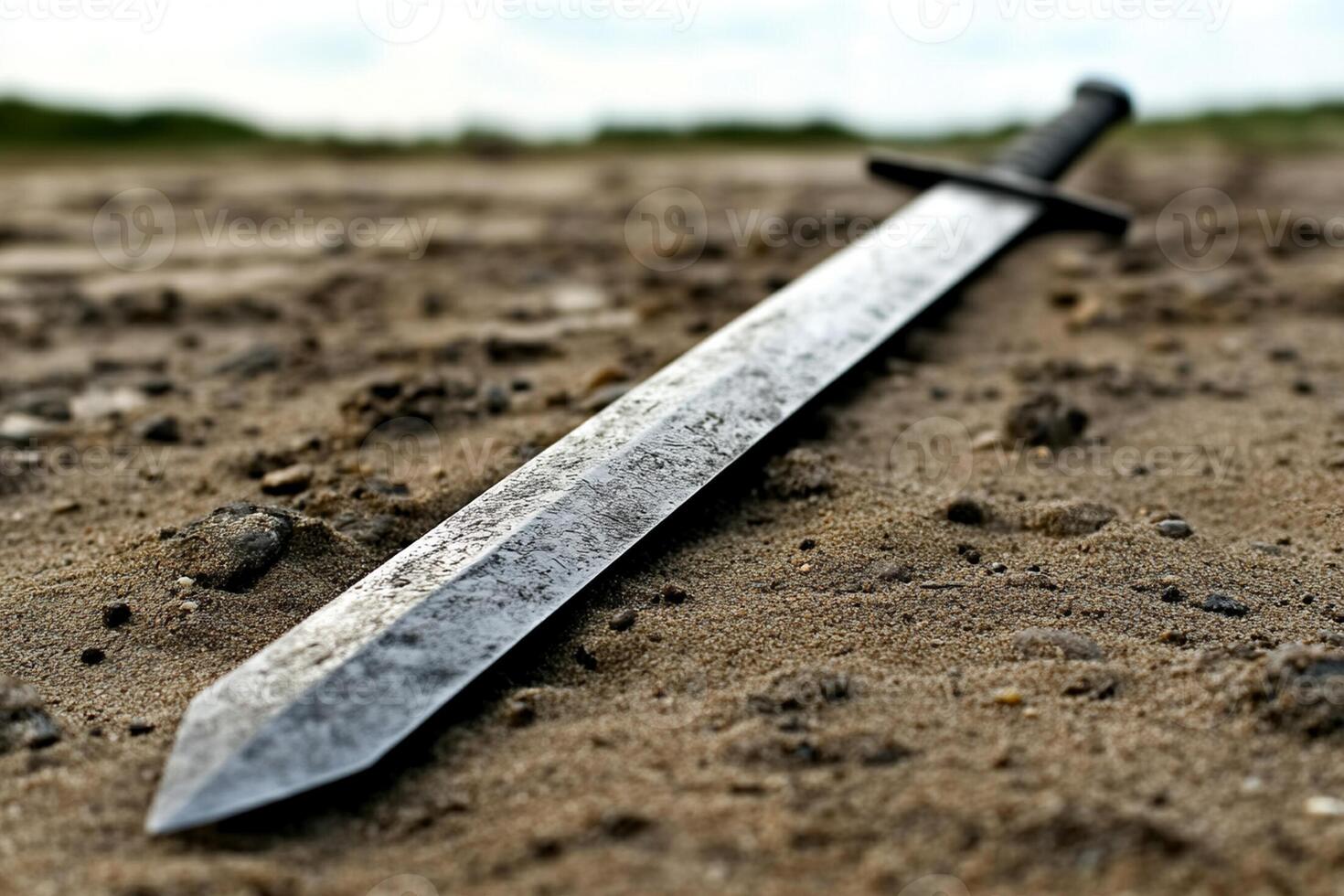 A sword laying on the ground in the sand photo