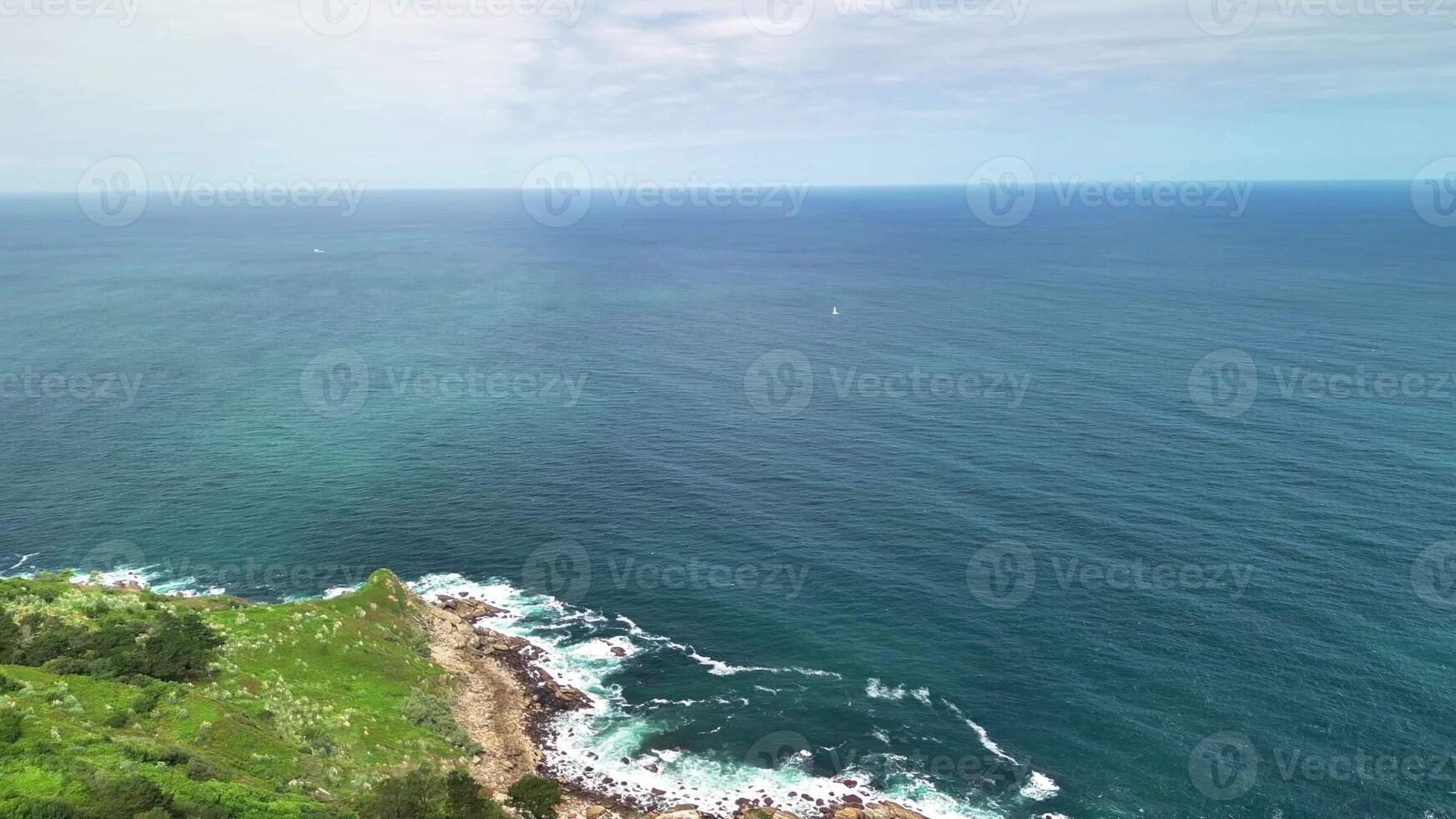 Experience breathtaking aerial views of cliffs and vibrant greenery along the picturesque coastal shoreline photo