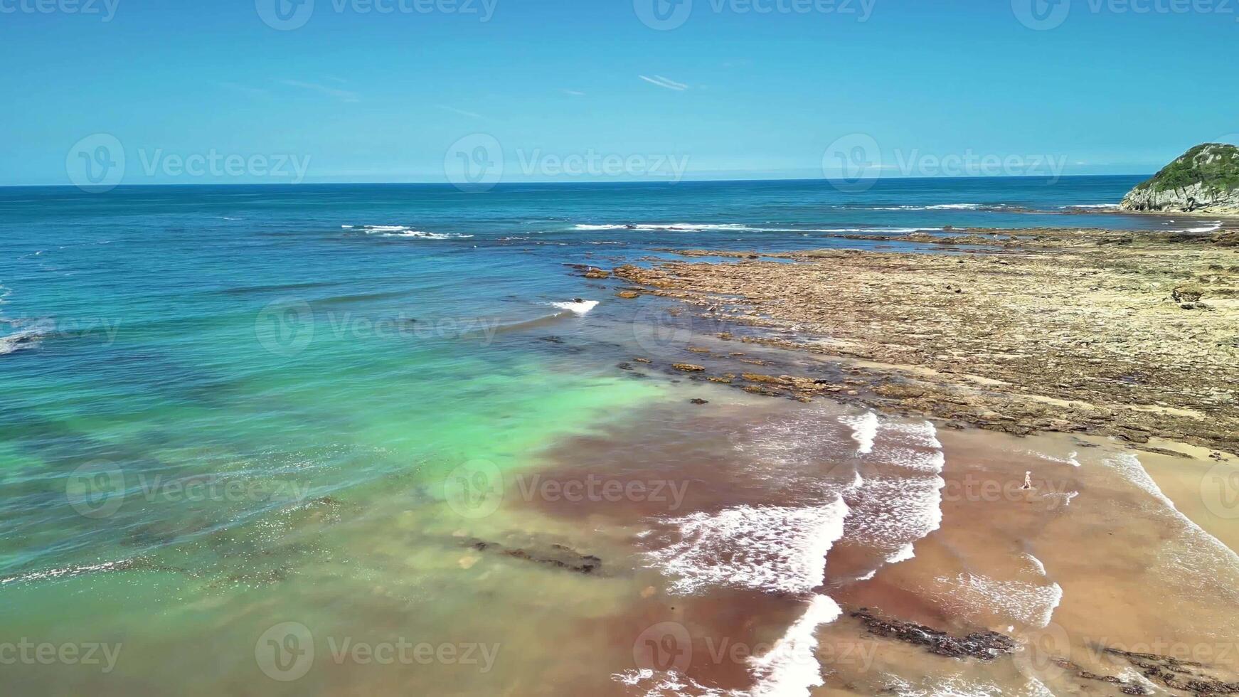 Stunning coastal scenery showcasing crystal clear turquoise waters and rugged rocky shorelines beneath a sunny sky photo