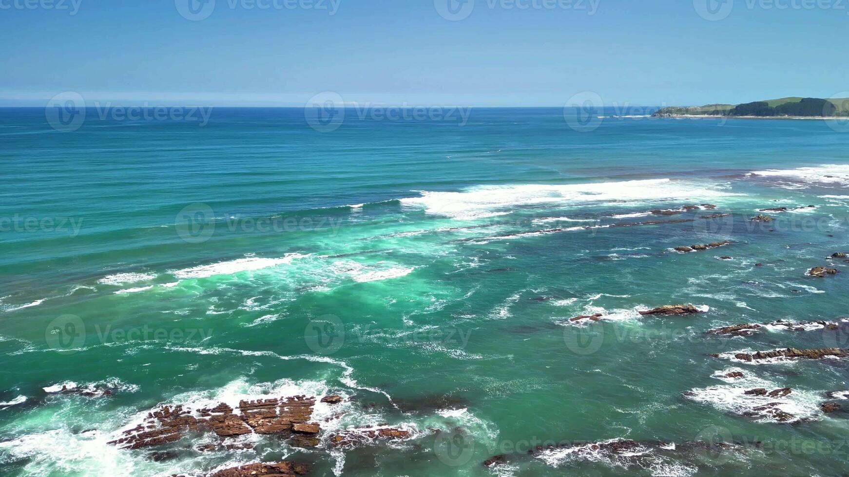 Be amazed by the breathtaking view of a serene coastline with crystal clear turquoise waters and lush greenery photo