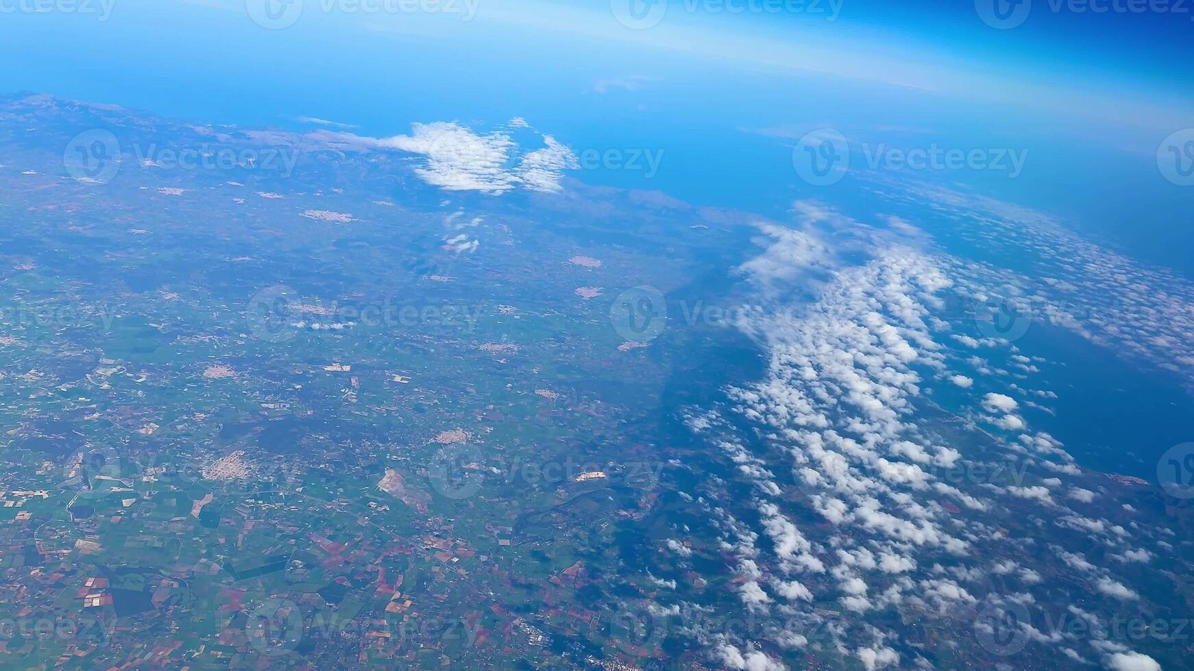 A breathtaking and captivating perspective of Earth showcasing both clouds and land from a notably high altitude photo
