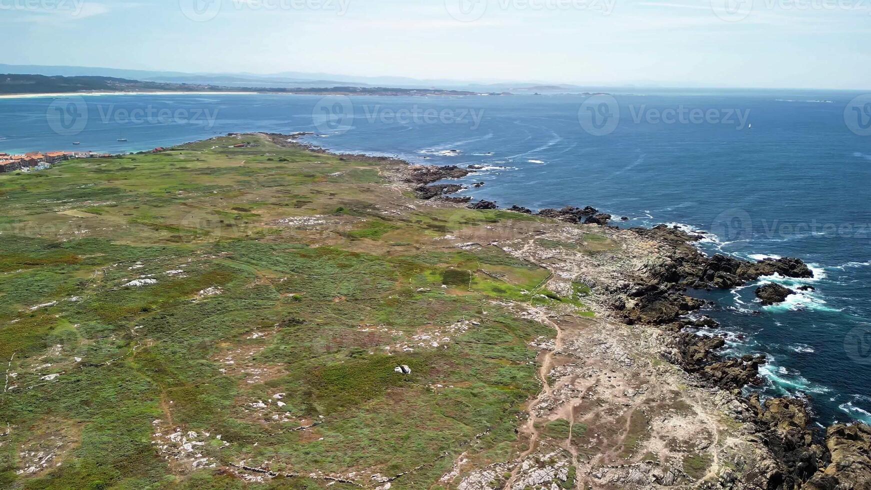Stunning aerial view showcasing a breathtaking coastline with rocky shores, vibrant greenery, and the ocean beyond photo
