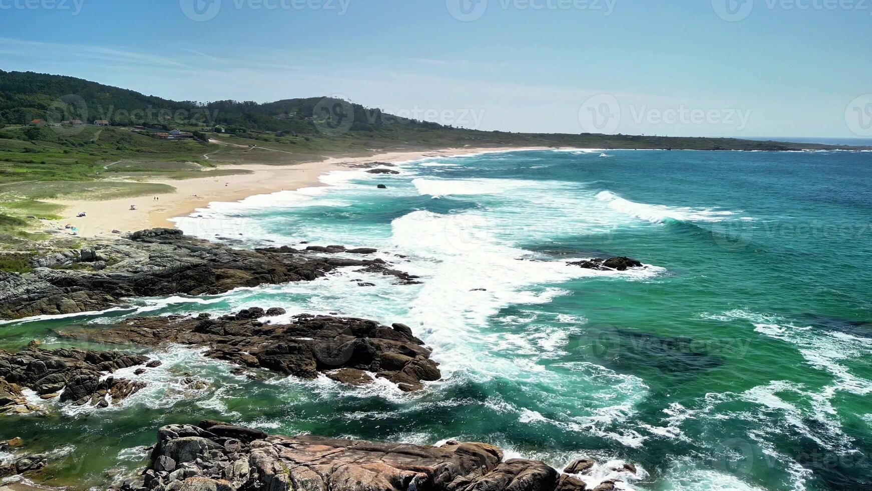 A truly breathtaking and picturesque view of the beach featuring crashing waves, rocky shores, and lush greenery photo