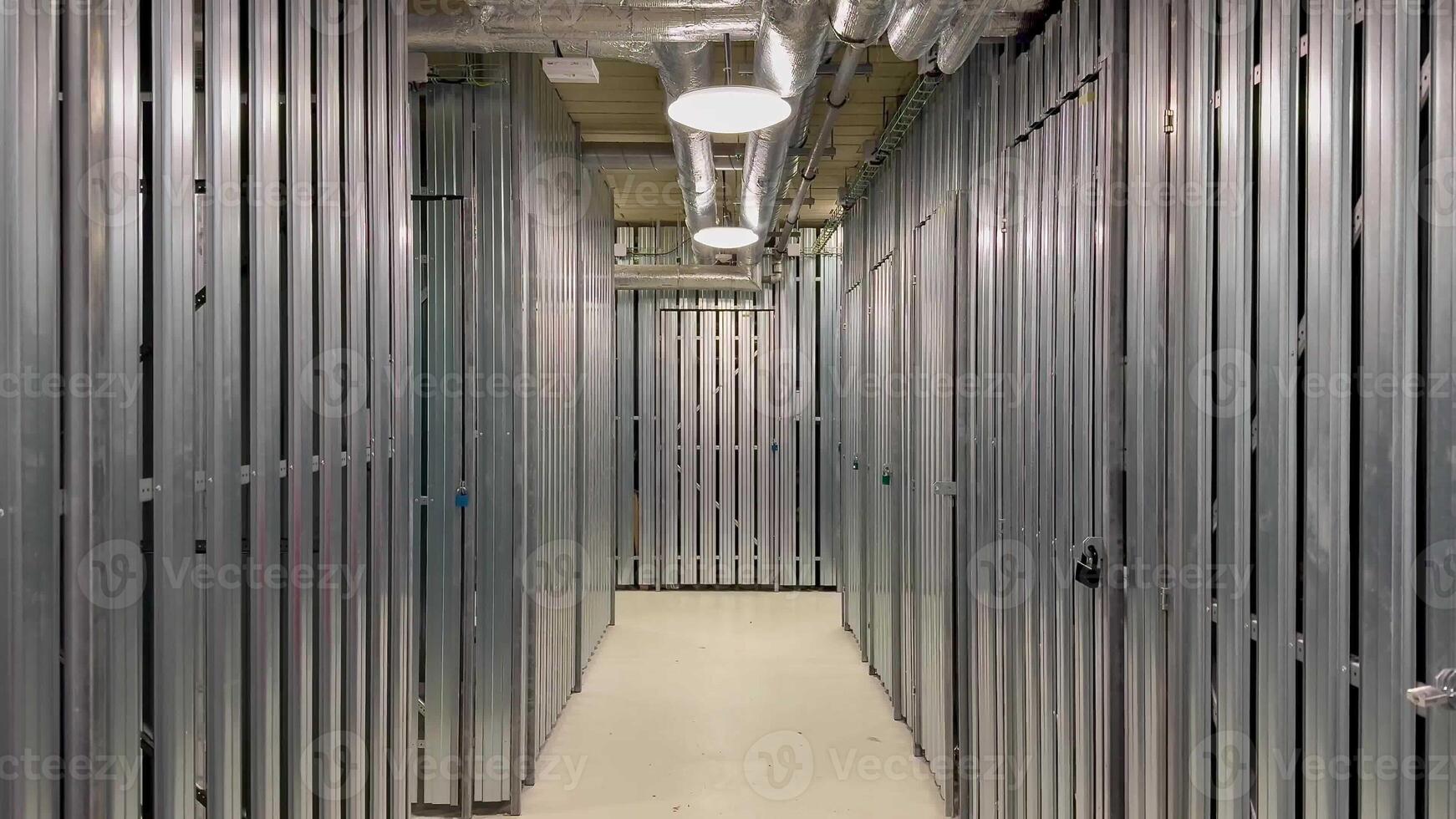 A contemporary storage facility aisle showcases sleek metal partitions and bright, effective lighting solutions photo