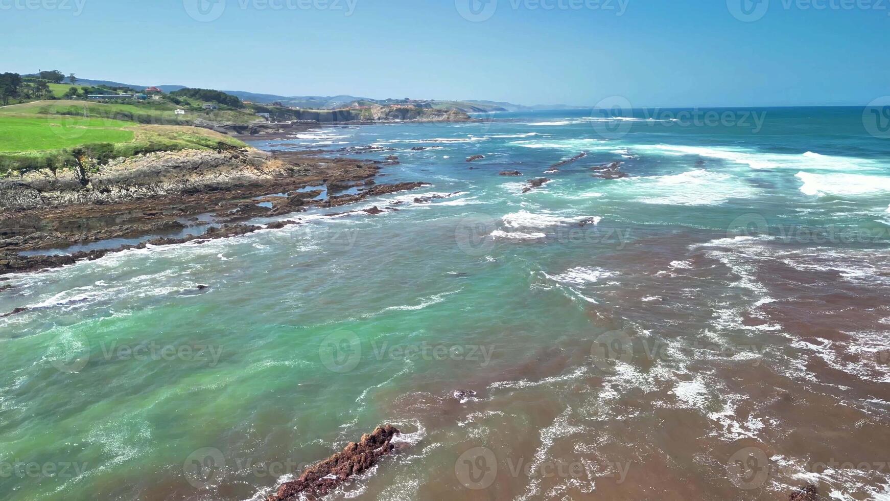 The coastal scenery features stunning turquoise waters and unique rock formations under a bright blue sky photo