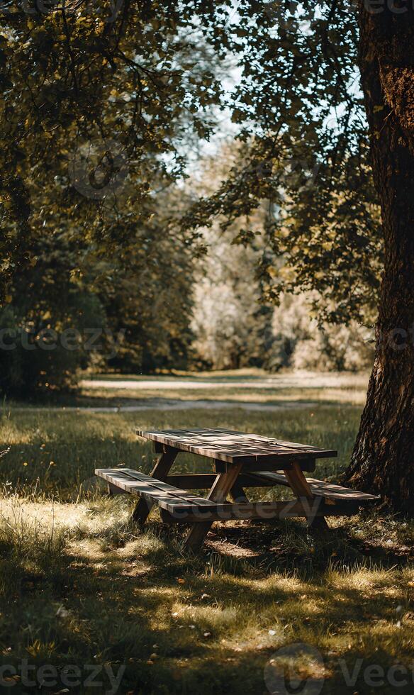 Rustic picnic table invites peaceful outdoor dining under the shade of towering trees on a sunny day photo