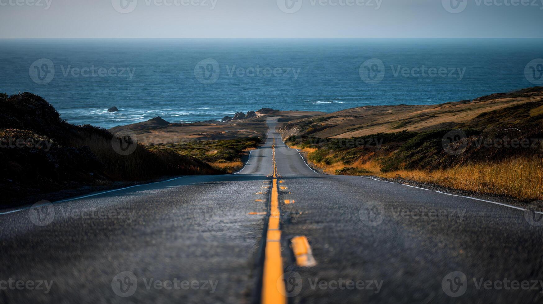 Scenic coastal highway offering a path to the horizon with the vast ocean in the background photo