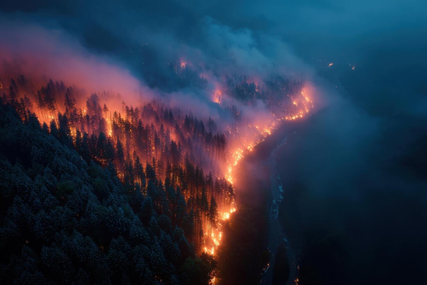 Flames engulf trees and hills as a forest fire blazes along riverbanks at dusk, creating a dramatic and urgent landscape photo
