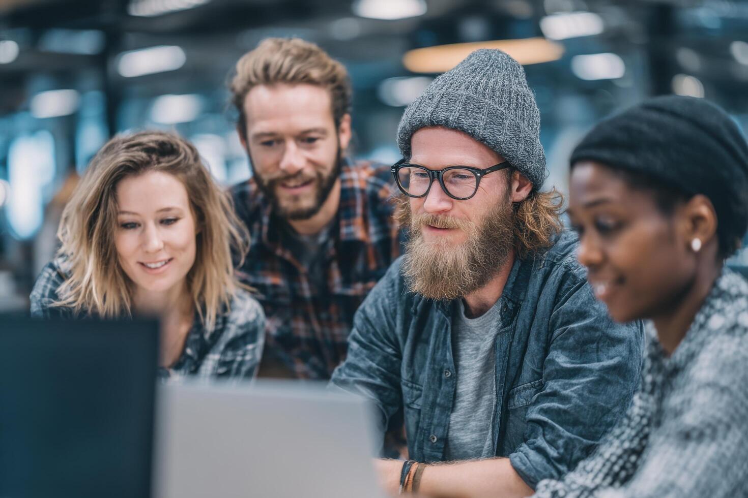 A diverse group of young adults are engaged in collaborative discussions while working on projects at a sleek office space during the day photo