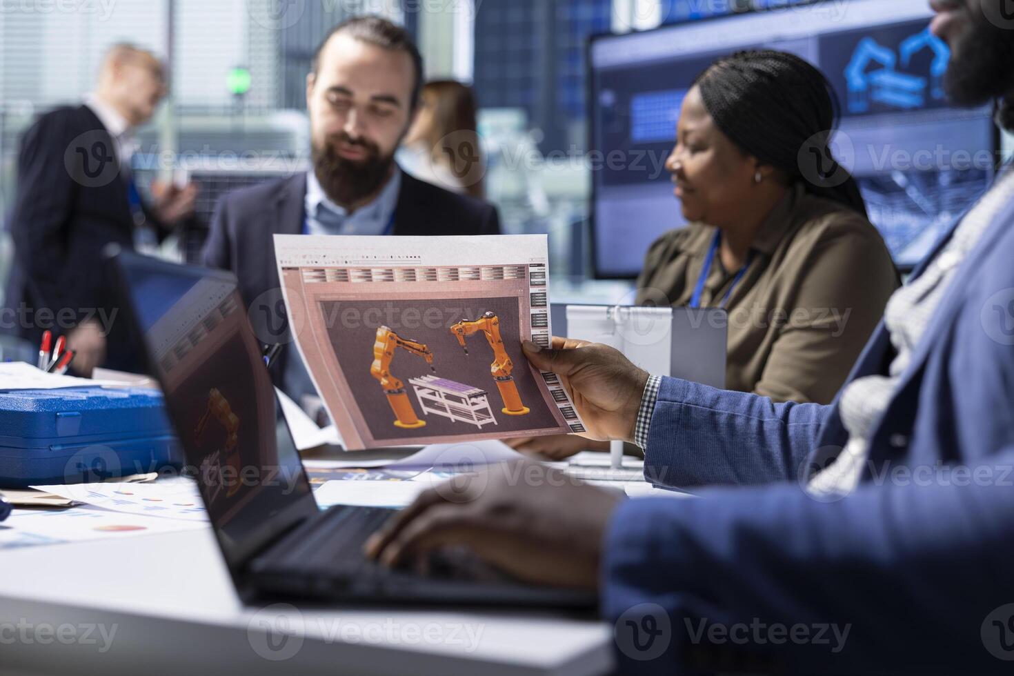 Industrial plant managers look over schematics, planning facility upgrades using laptop. Factory shareholders look over conveyor belts blueprints, working on notebook device photo