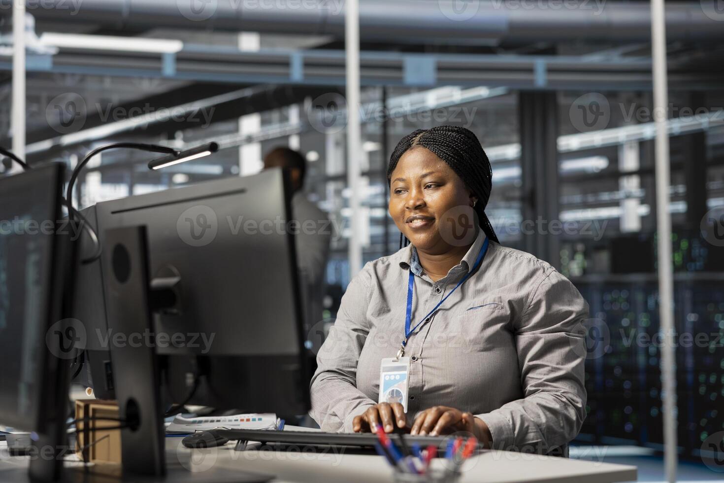 Jolly data center admin analyzing software logs metrics on PC, optimizing storage systems. Joyous server room worker inspecting resource utilization on computer, managing application efficiency photo