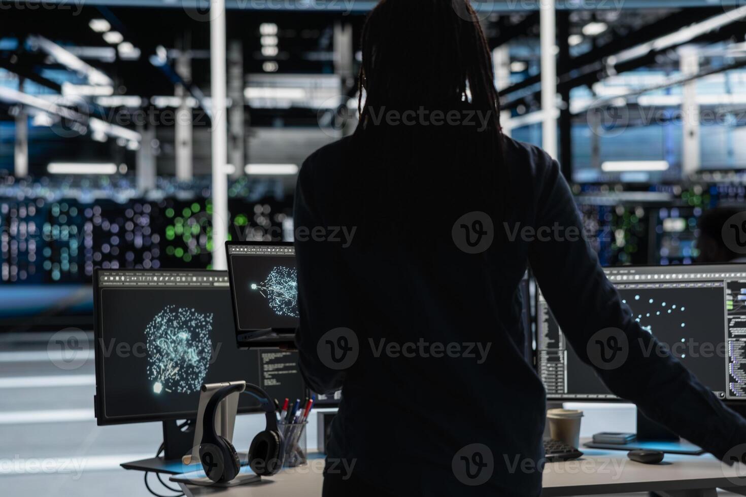 Data center engineer uses AI visualization tool on laptop to oversee automated repetitive tasks. Worker adapting server systems based on data analytics graphs using notebook device photo