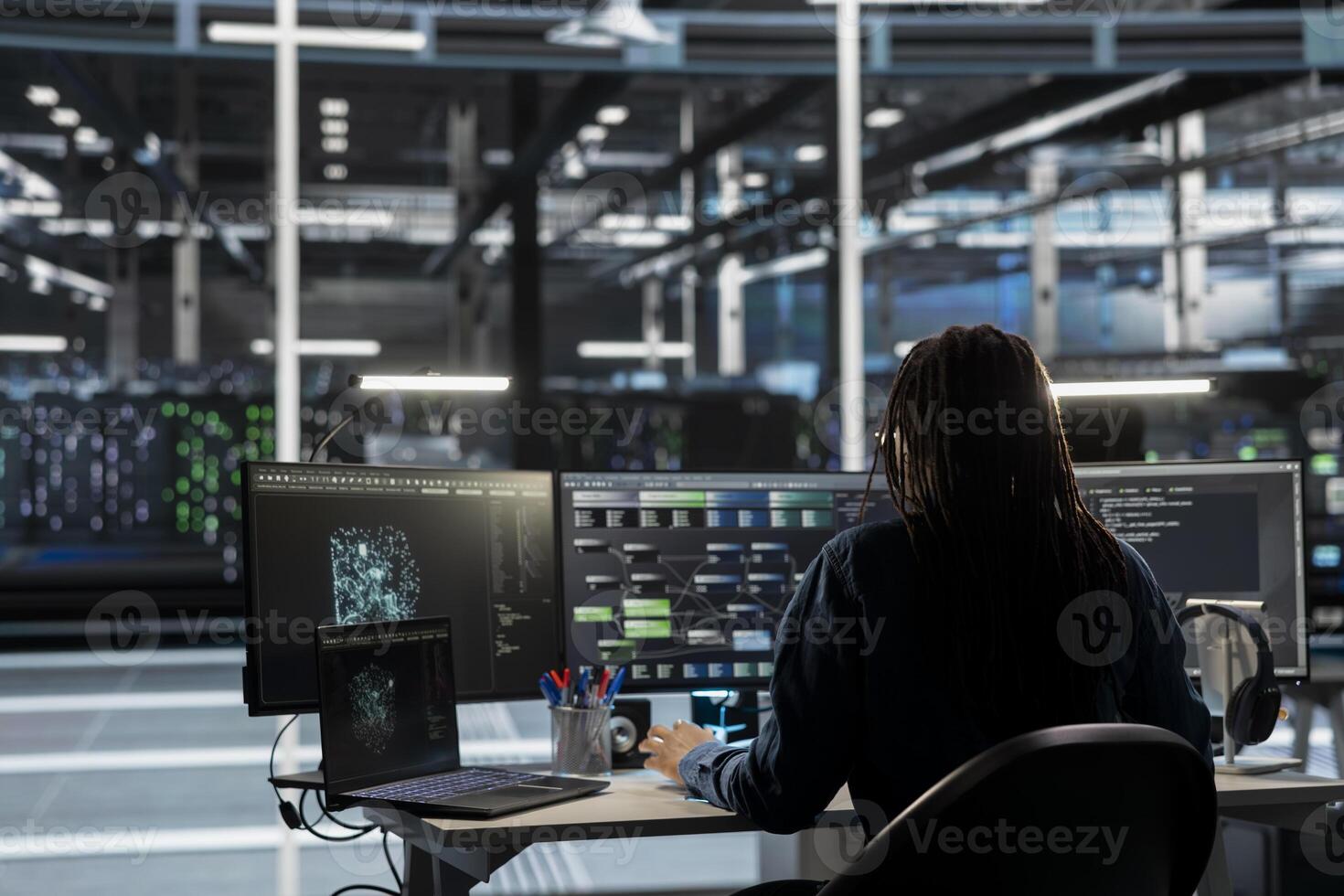 Data center engineer uses AI visual programming to oversee automated repetitive tasks minimizing manual intervention. Worker adapting server systems based on data analytics graphs photo