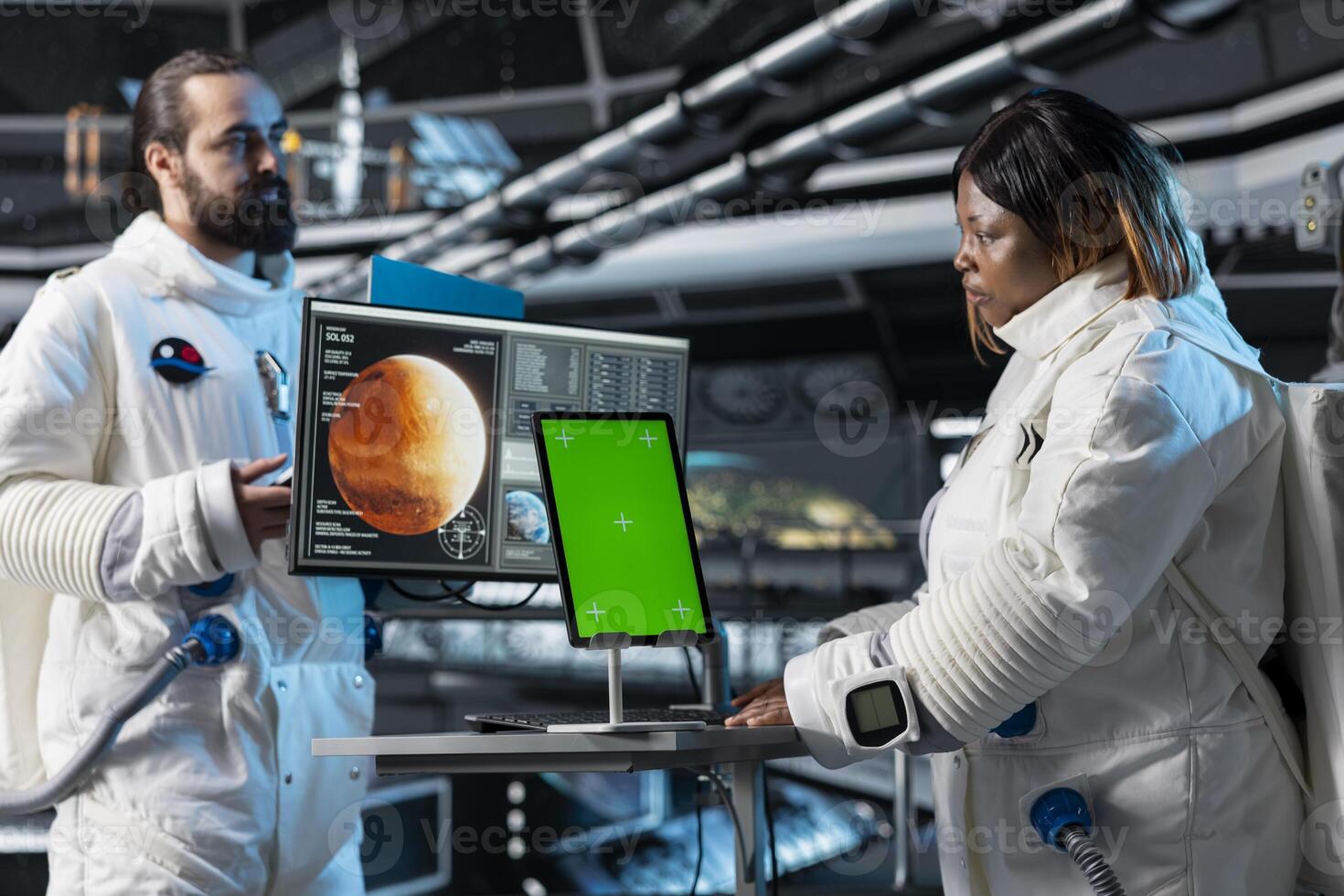Cosmonauts study mission plans on green screen tablet before Mars expedition, preparing for future of mankind. Astronauts use chroma key device, exploring red planet to support human life beyond Earth photo