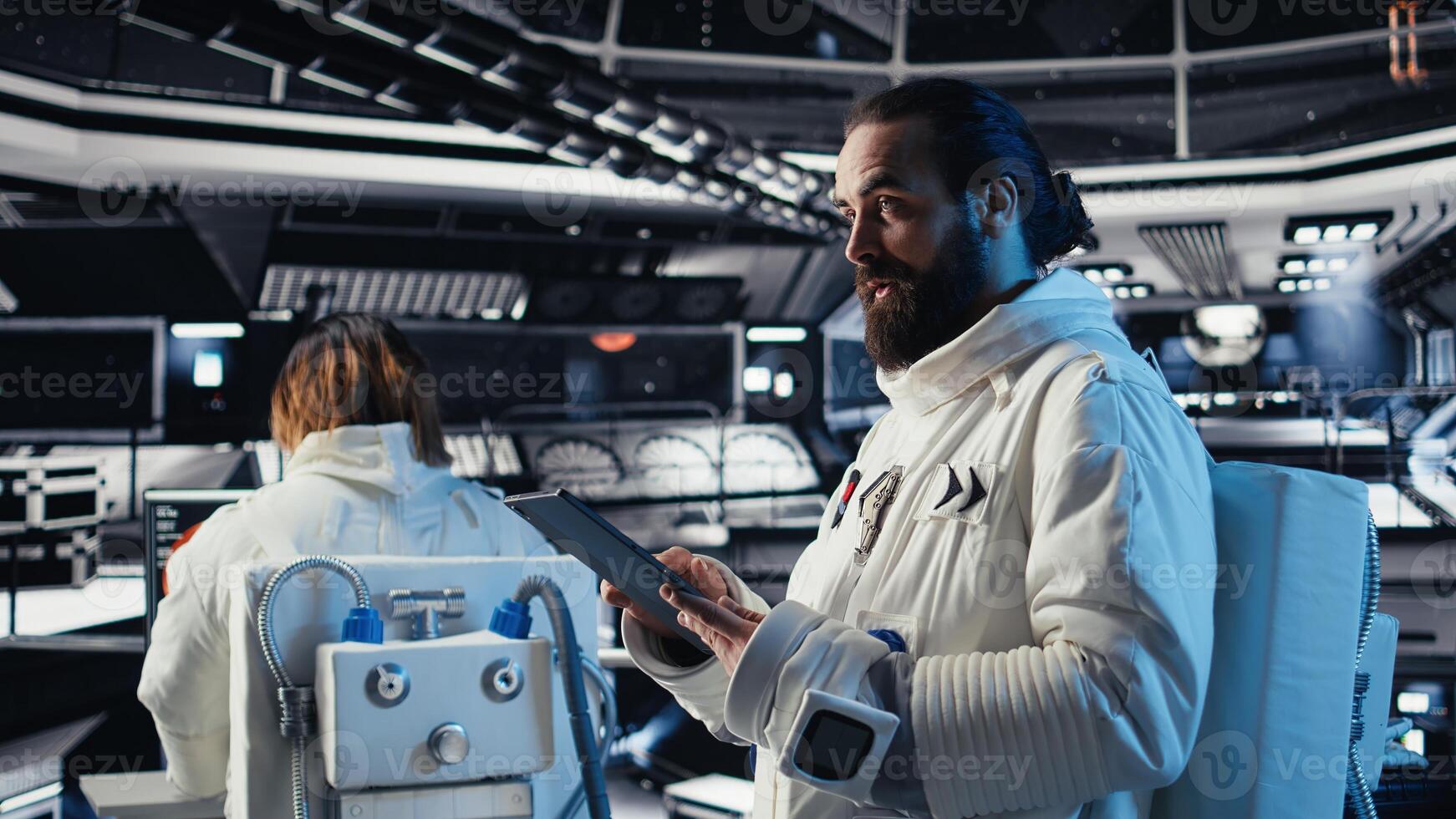 Cosmonaut using tablet in spaceship conducting safety checks during mankind survival expedition. Astronauts monitoring life support systems during human expansion in space mission photo