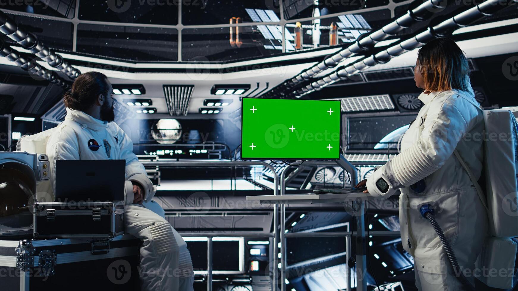 Astronauts checking human expansion in space mission logs on isolated screen monitor. Teamworking cosmonaut looking at mockup display during mankind survival expedition photo