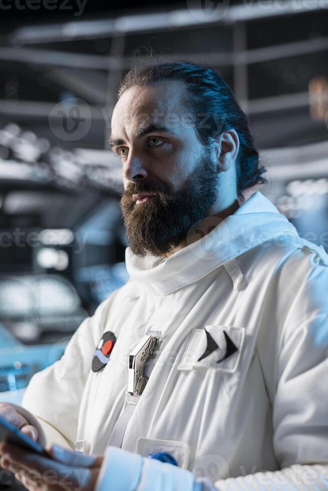 Astronaut wearing spacesuit inside futuristic spacecraft planning cosmic journey. Spaceman wearing equipment prepares for space travel operation of observing distant planets photo