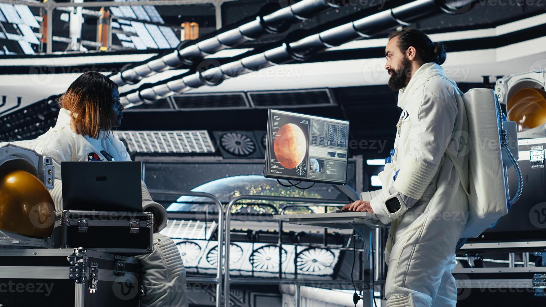 Astronaut monitoring system diagnostics on monitor, talking to colleague during human expansion in space mission. Teamworking cosmonaut doing brainstorming during mankind survival expedition photo