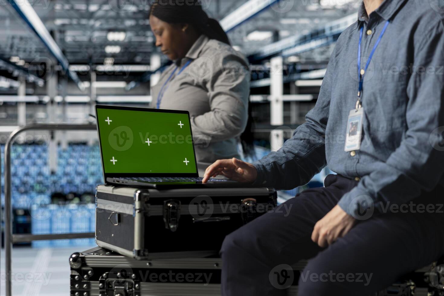 Close up of data center employee using green screen notebook, managing automation scripts for optimized operations. Engineer using mockup laptop in server farm, maintaining optimal system performance photo