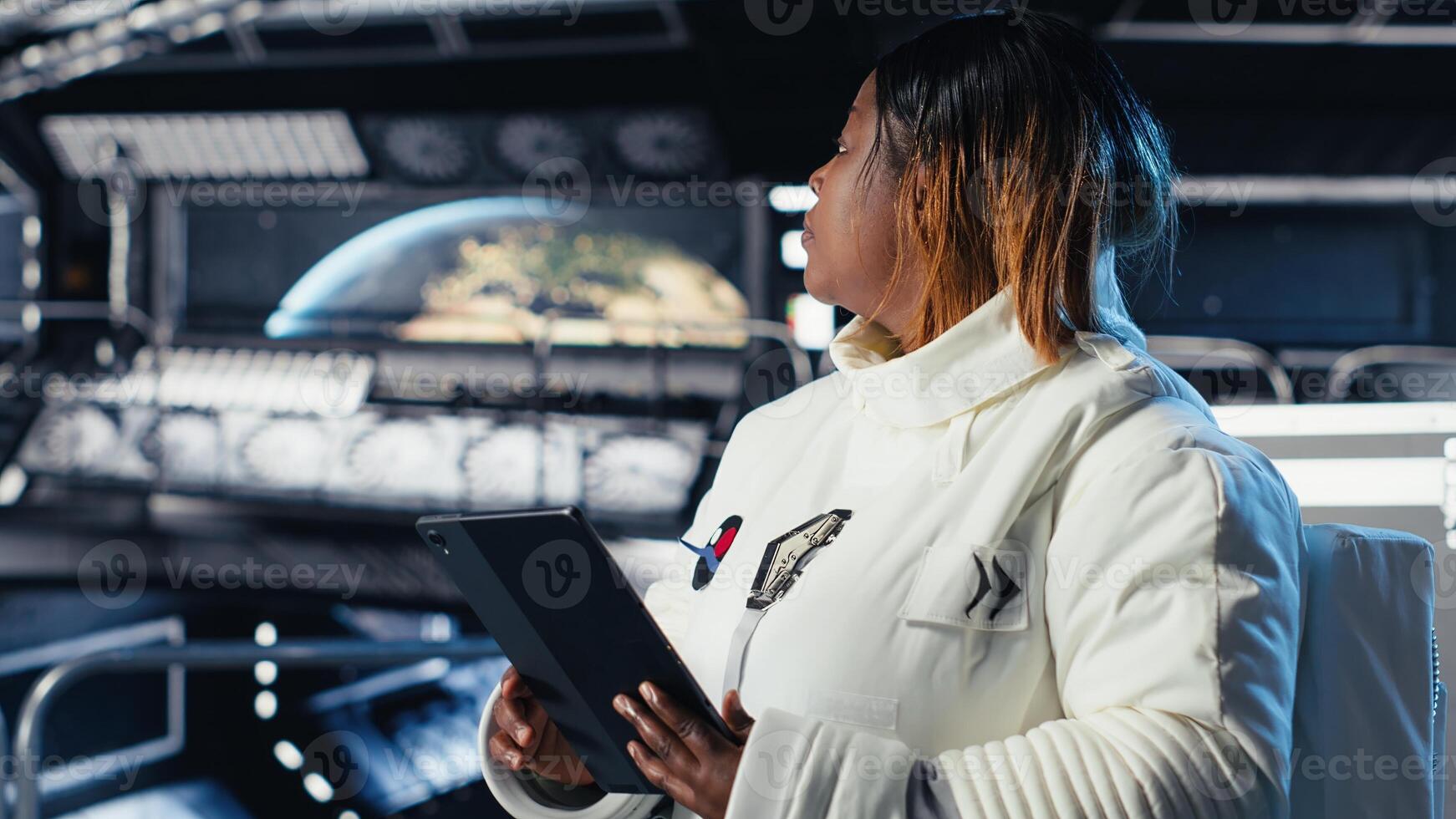Female astronaut using tablet to check space station analytics after completing surface mission on unfamiliar planet. Woman inputting navigation coordinates, preparing for return to Earth photo