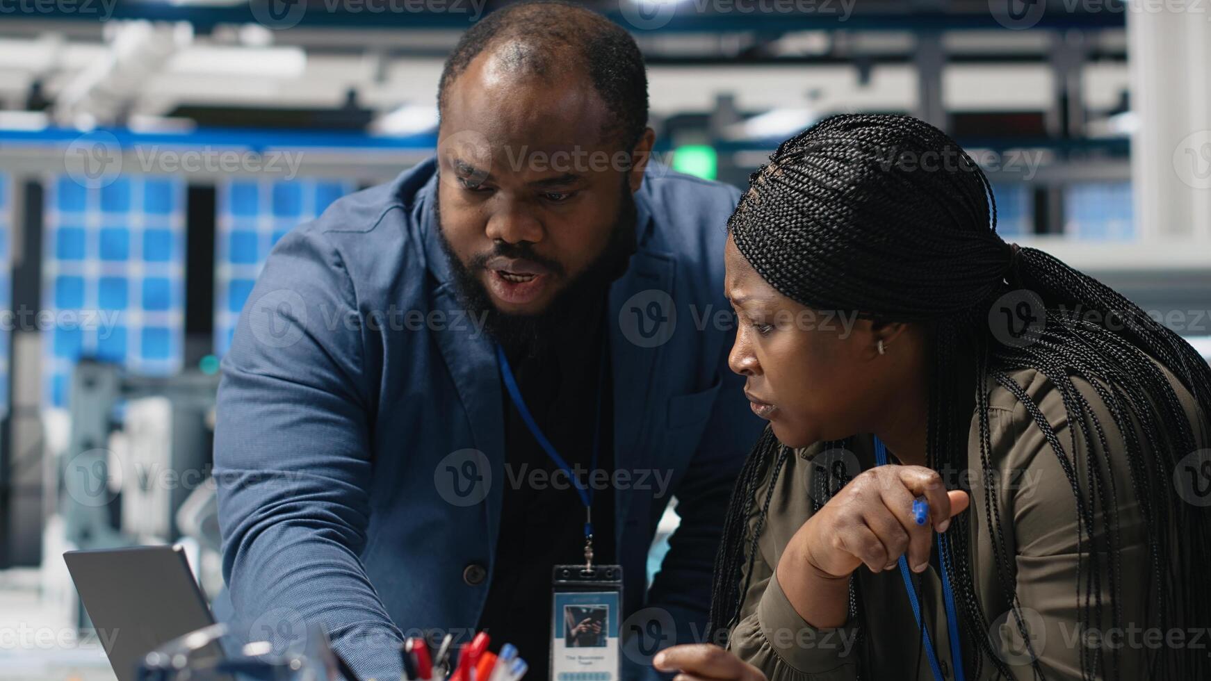African american team of technical experts work on briefing in high tech power plant, planning future developments in renewable energy and industrial operations. Manufacturing process. Camera B. photo