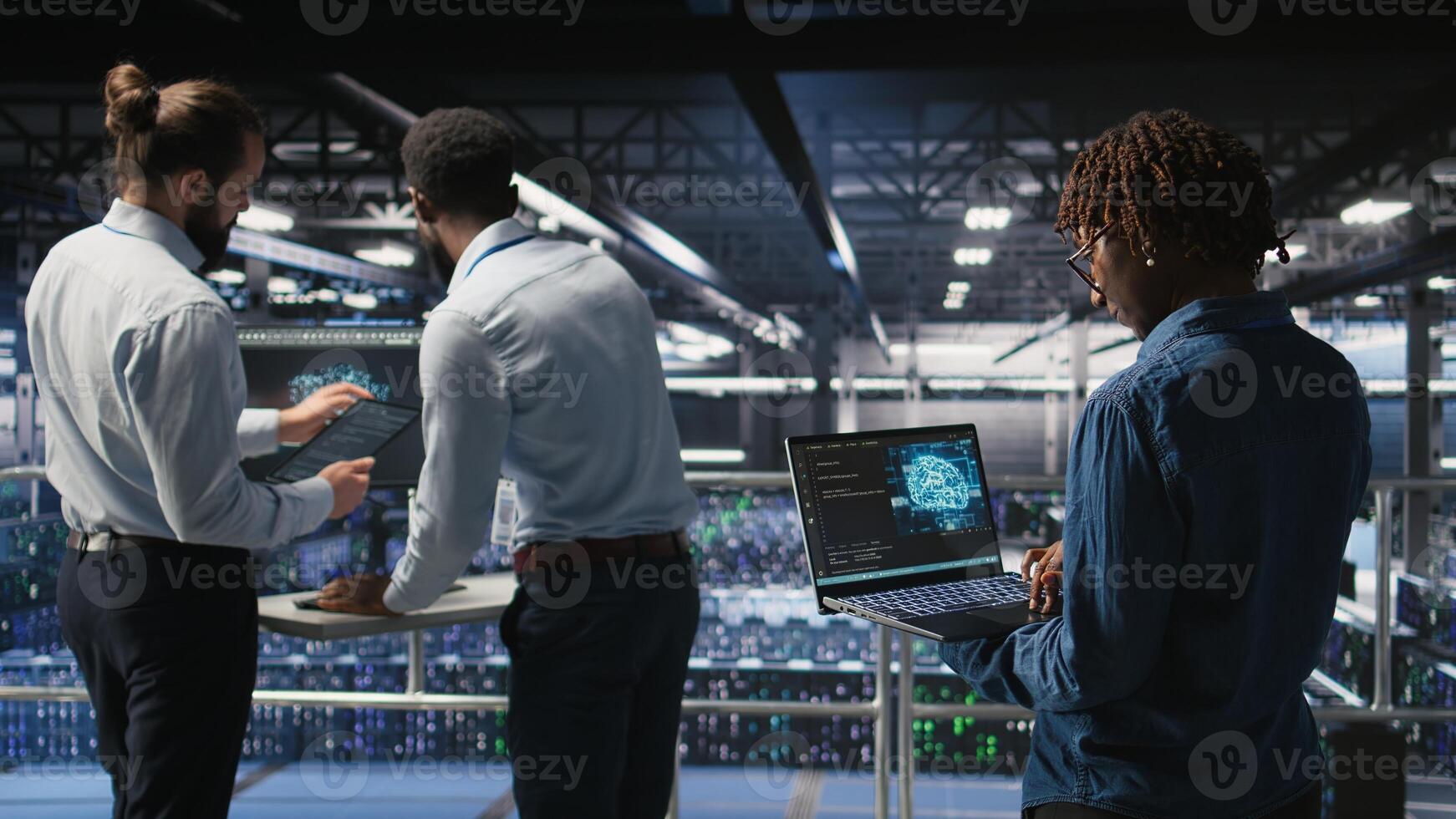 Data center system administrators collaborating to maintain servers using artificial intelligence. Teamworking colleagues doing infrastructure AI machine learning automatization, photo