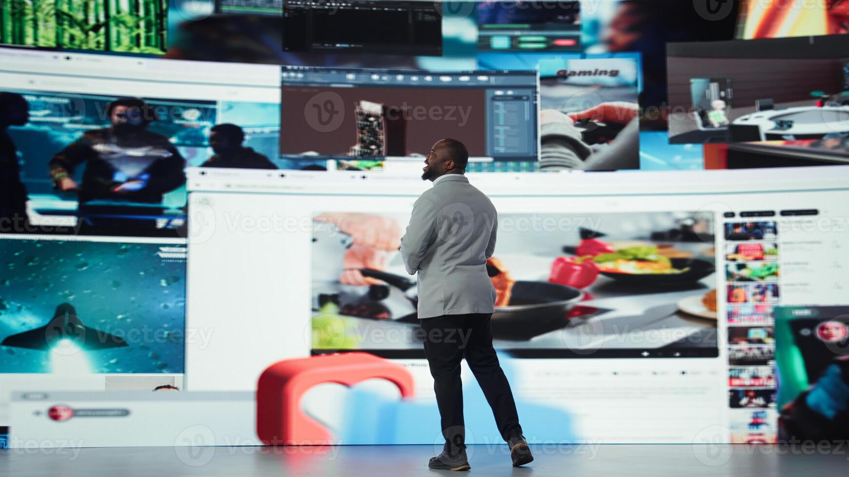 Delighted man entering world of online media, enjoying access to thousands of streaming videos. Ecstatic user surrounded by previews highlighting diverse internet content, camera A photo