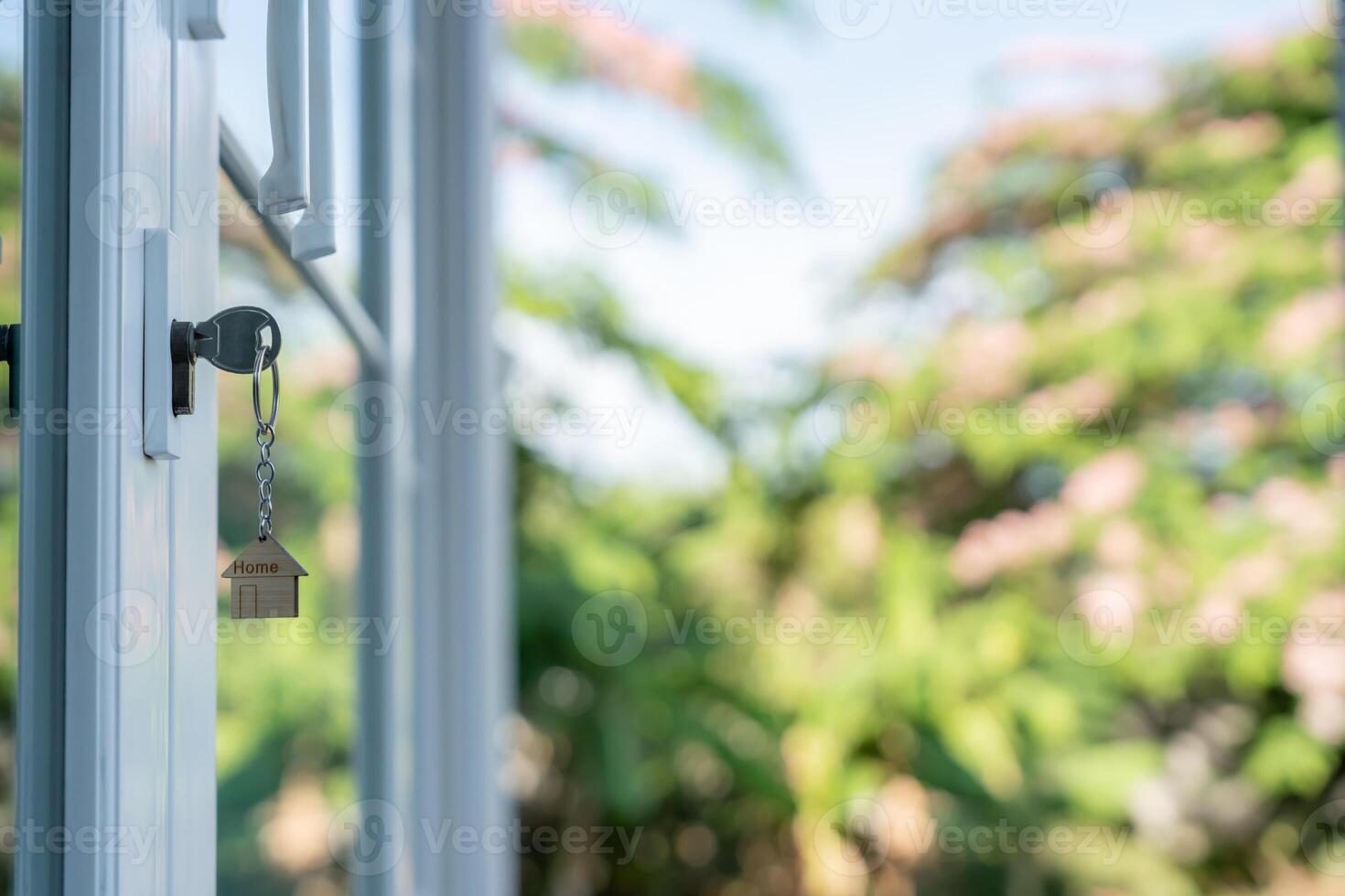 unlocking house is plugged into the door. Second hand house for rent and sale. keychain is blowing in the wind. mortgage for new home, buy, sell, renovate, investment, owner, estate, photo