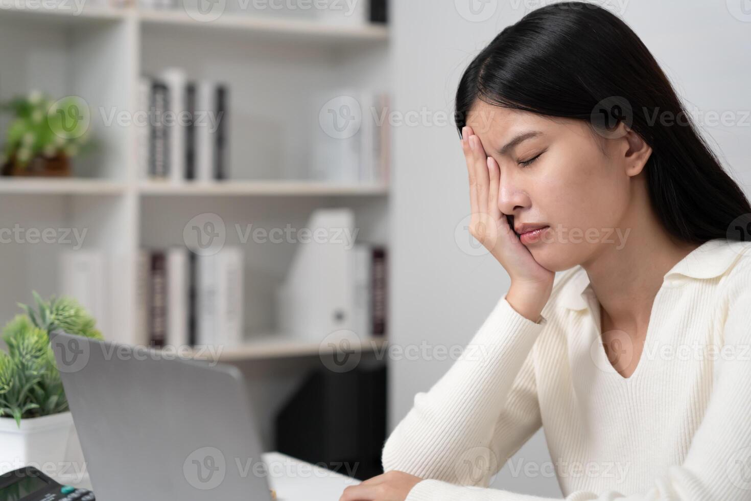 Eye problem Asian women with tired and irritated eyes, eye rubbing, dry, eye pain after work, migraine, headache, blurred vision, photophobia, working in the dark, blue light from computer screens photo