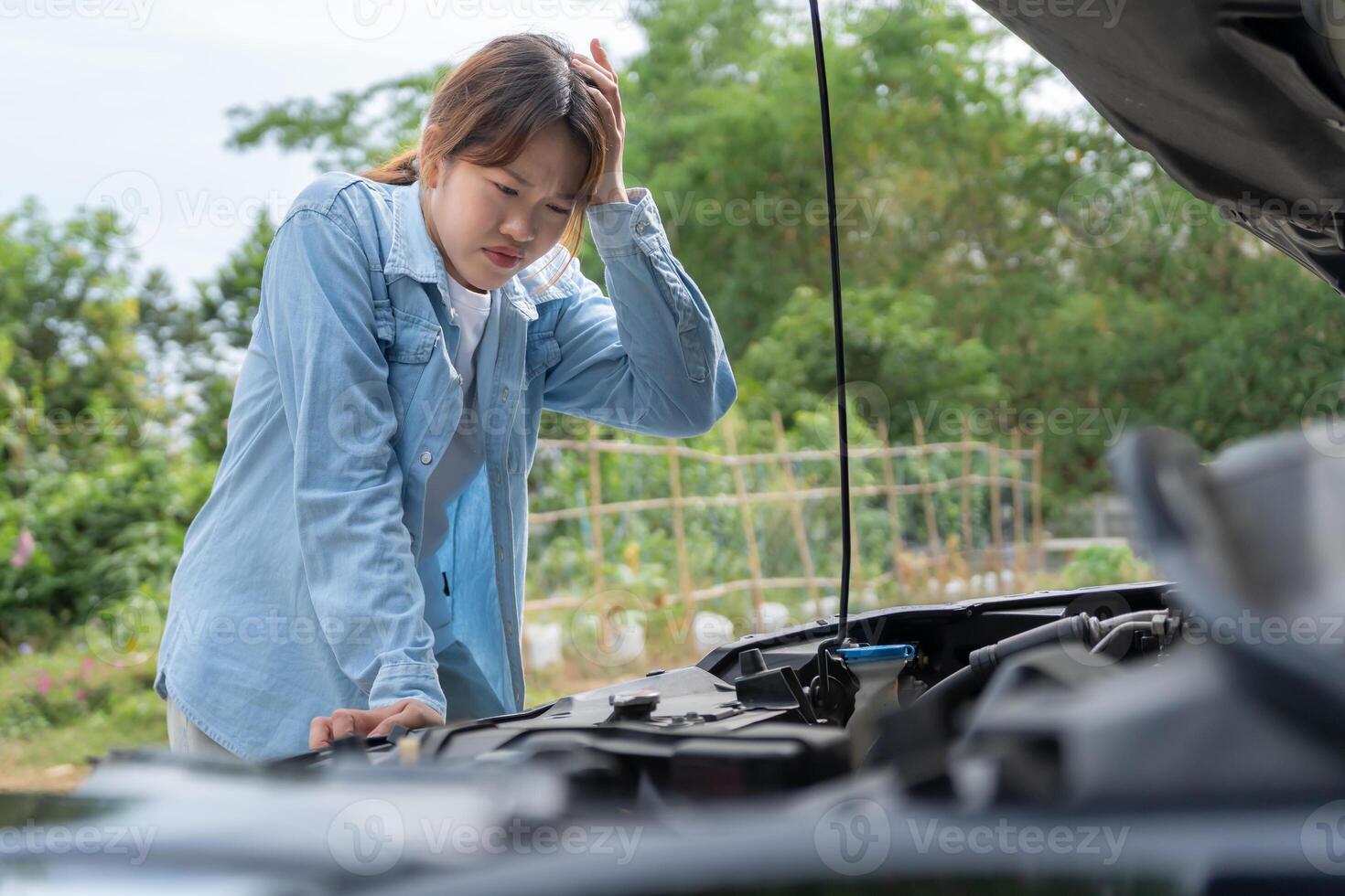Stress Woman look engine during car accident . Find garage to get car fixed during country tour, waiting for help, emergency. photo